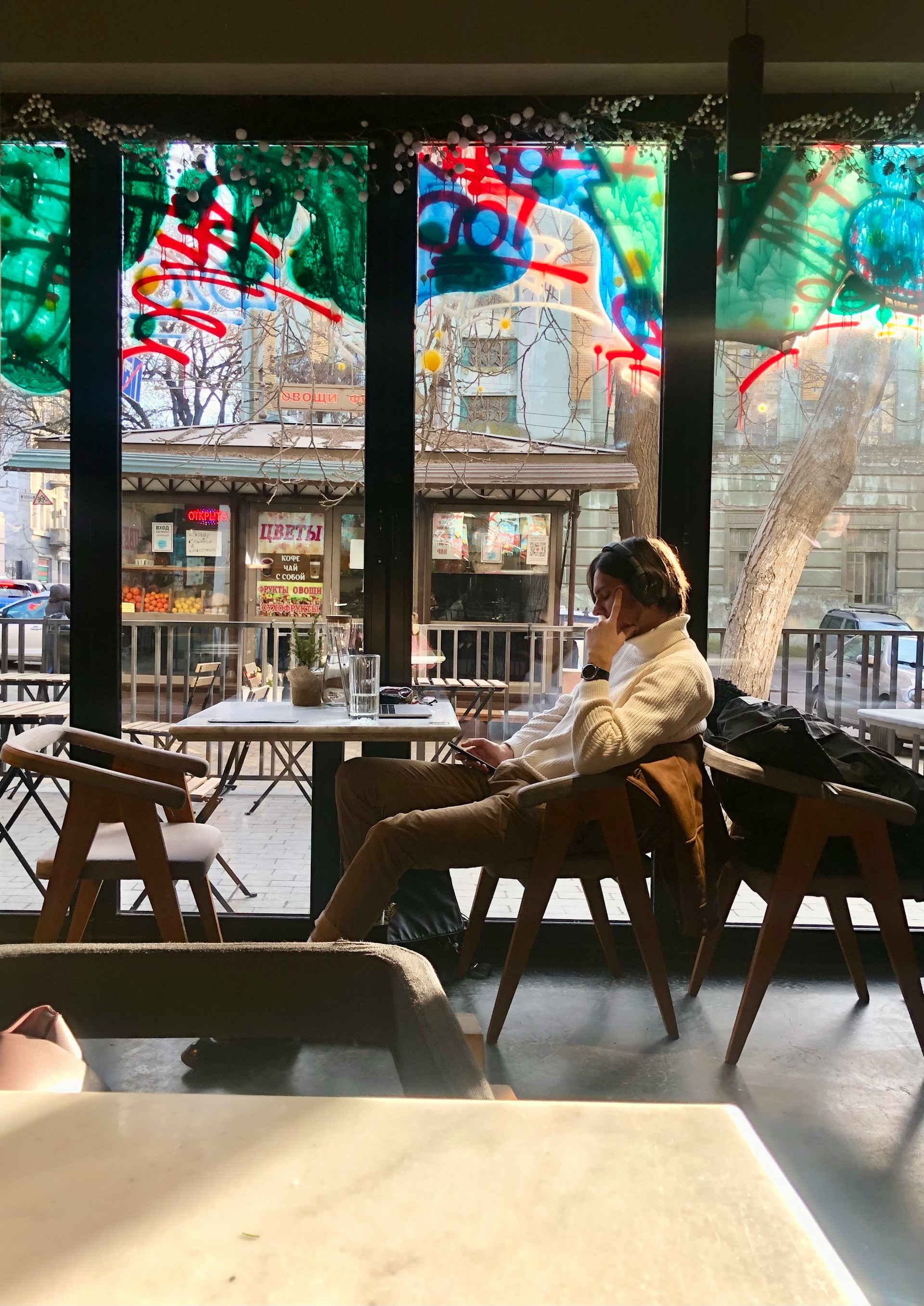 Ein junger Mann sitzt in einem Café | Quelle: Unsplash