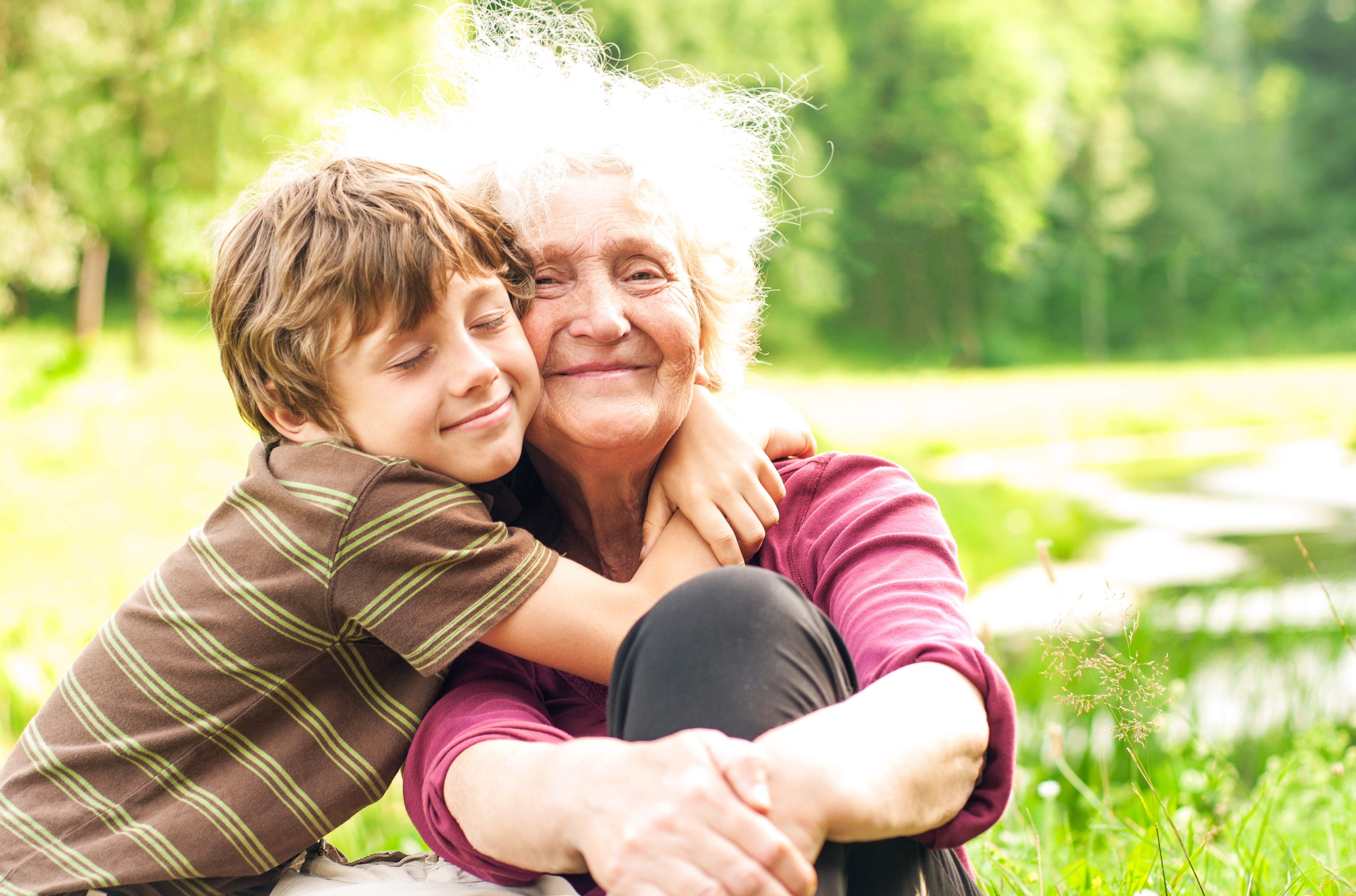 Eine Großmutter wird von ihrem Enkel herzlich umarmt | Quelle: Shutterstock