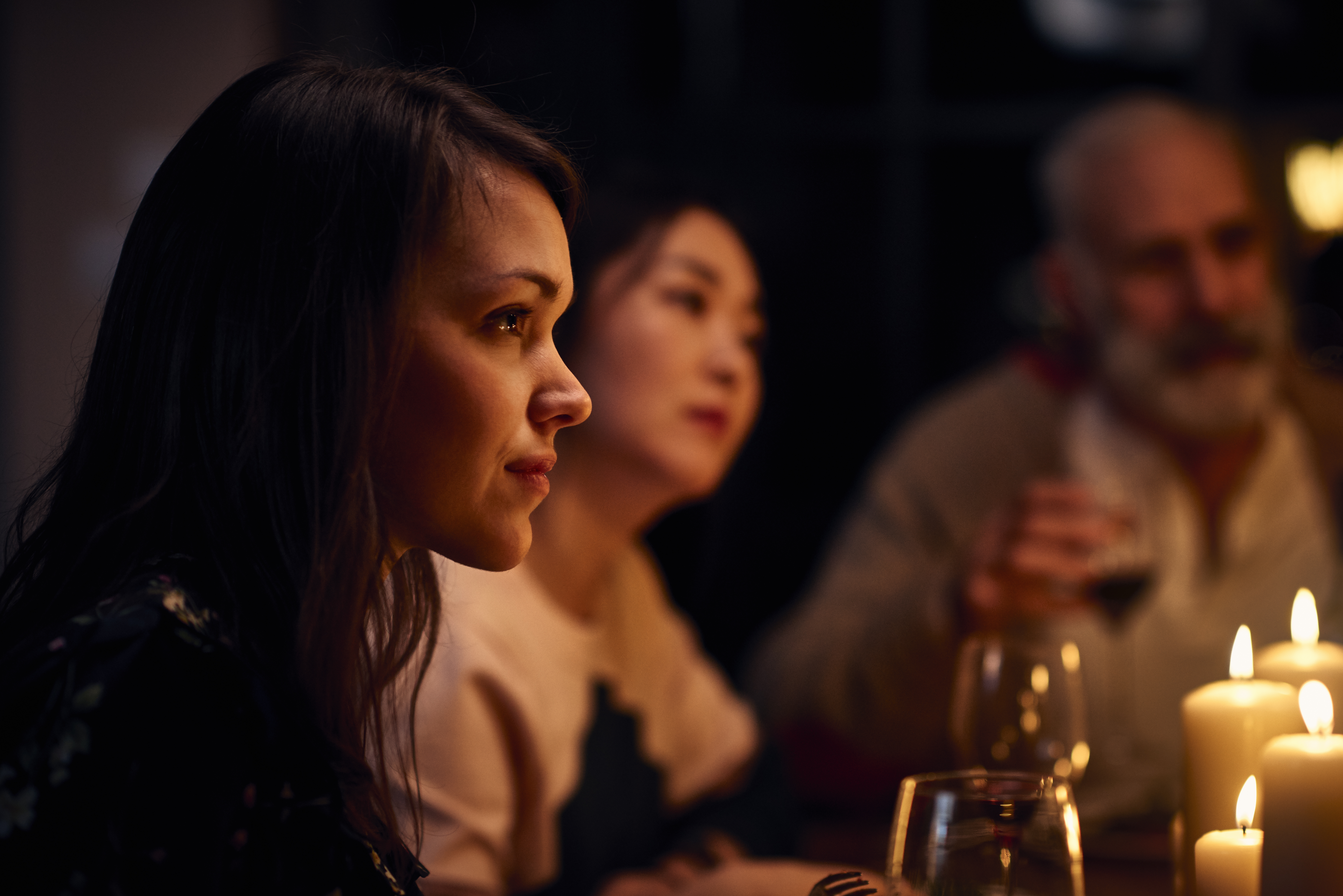 Gelassen wirkende Frau bei einer Dinnerparty, die aufmerksam zuhört | Quelle: Getty Images
