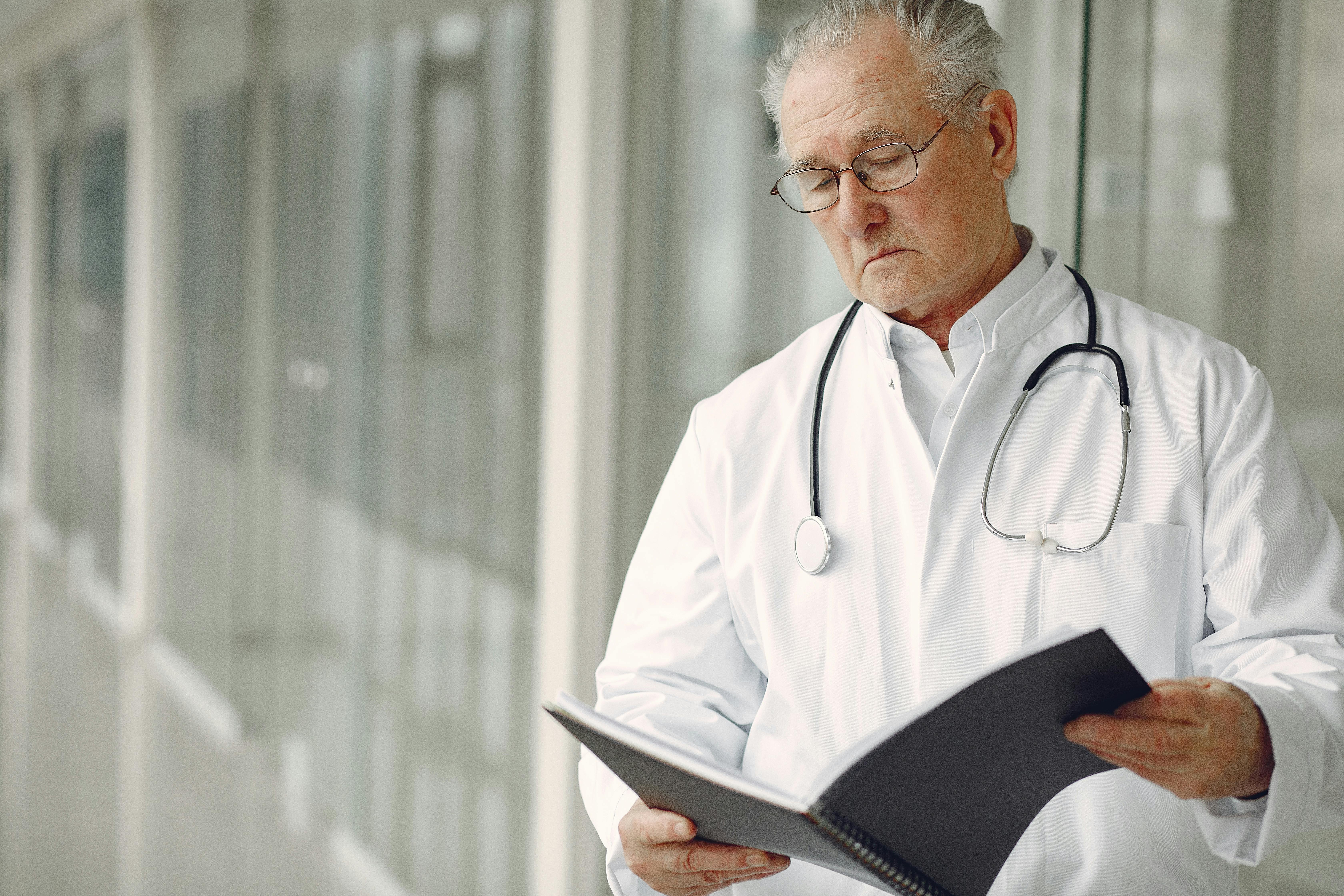 Ein Arzt, der die Unterlagen eines Patienten liest | Quelle: Pexels