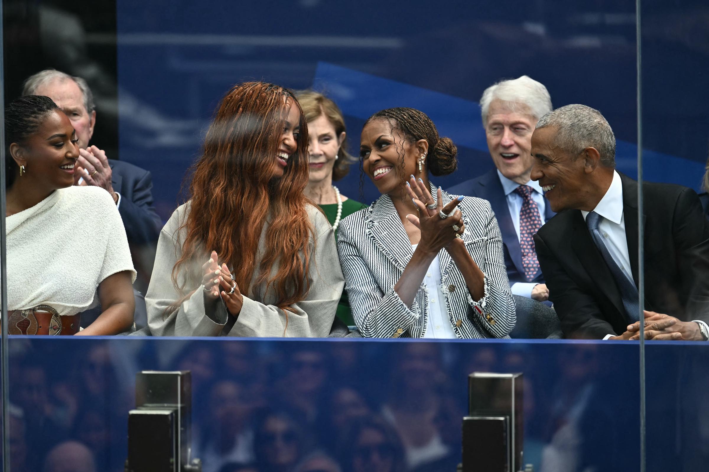 An einer Stelle nutzte Malia Obama ihr langes Haar, um sich zu bedecken, als sie bei der hochkarätigen Veranstaltung neben ihrer Familie herging. Auf diesem Foto ist die Familie zu sehen, wie sie bei der Eröffnung des Barack Obama Presidential Center in Chicago, Illinois, am 18. Juni 2026 zusammensitzt. | Quelle: Getty Images