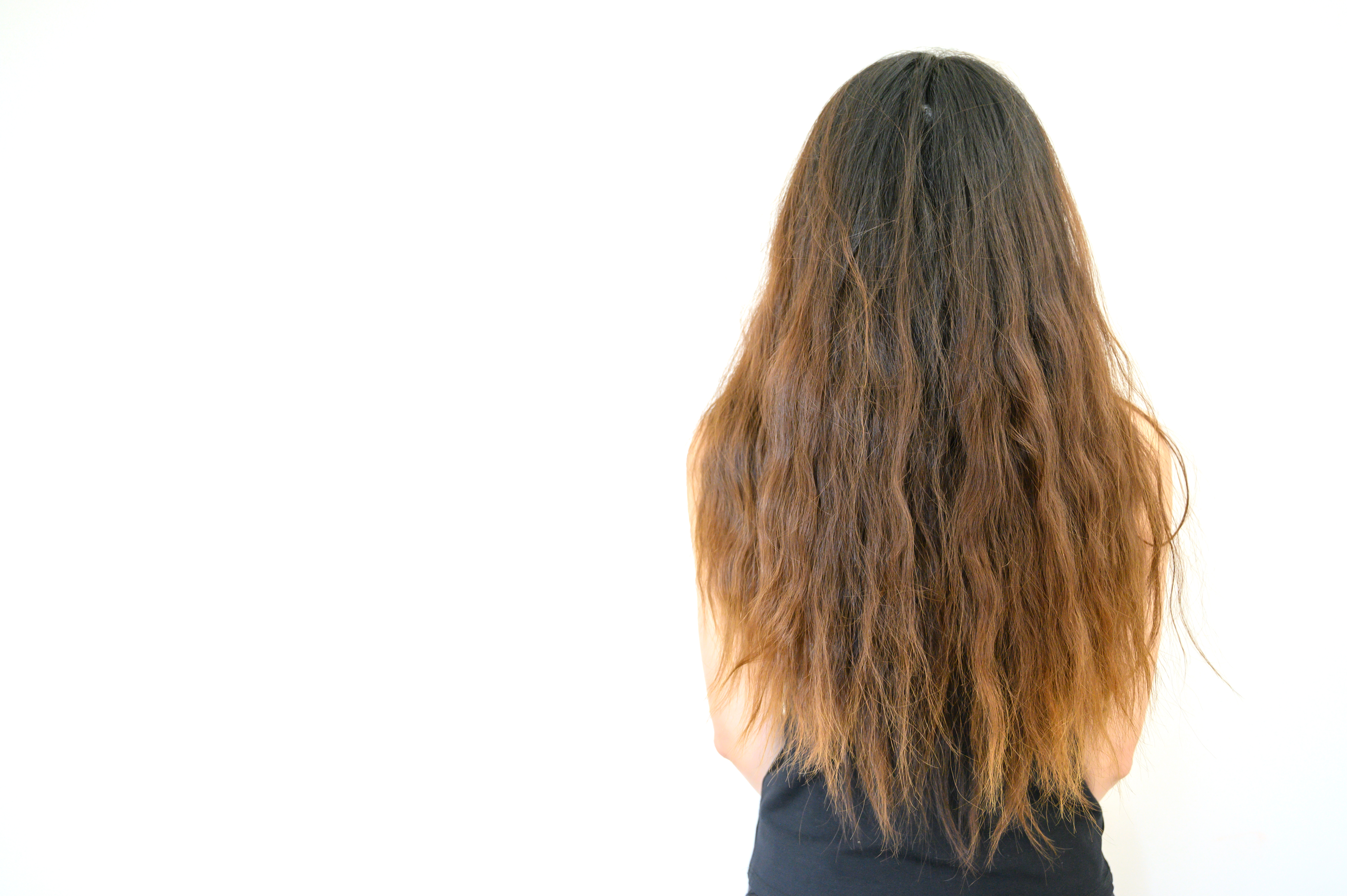 Rückansicht einer jungen Frau mit krausem Haar | Quelle: Shutterstock