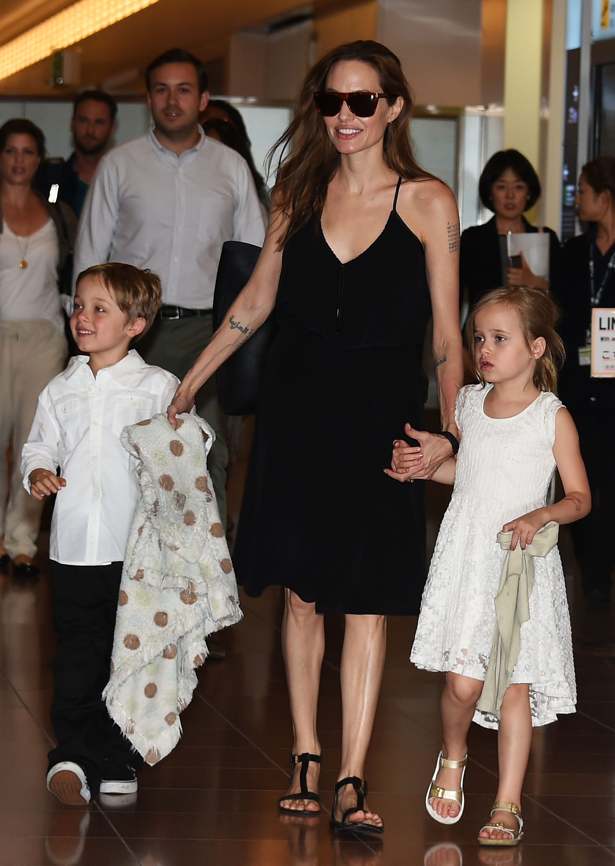 Knox Jolie-Pitt mit seiner Mutter und seiner Zwillingsschwester am Flughafen Haneda am 21. Juni 2014 in Tokio, Japan. | Quelle: Getty Images