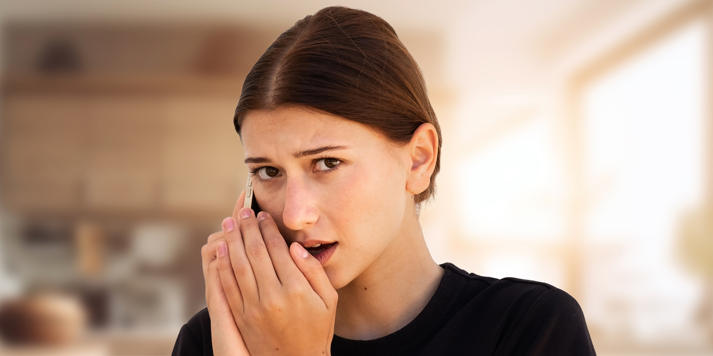 Eine junge Frau spricht heimlich in ihr Telefon | Quelle: Shutterstock