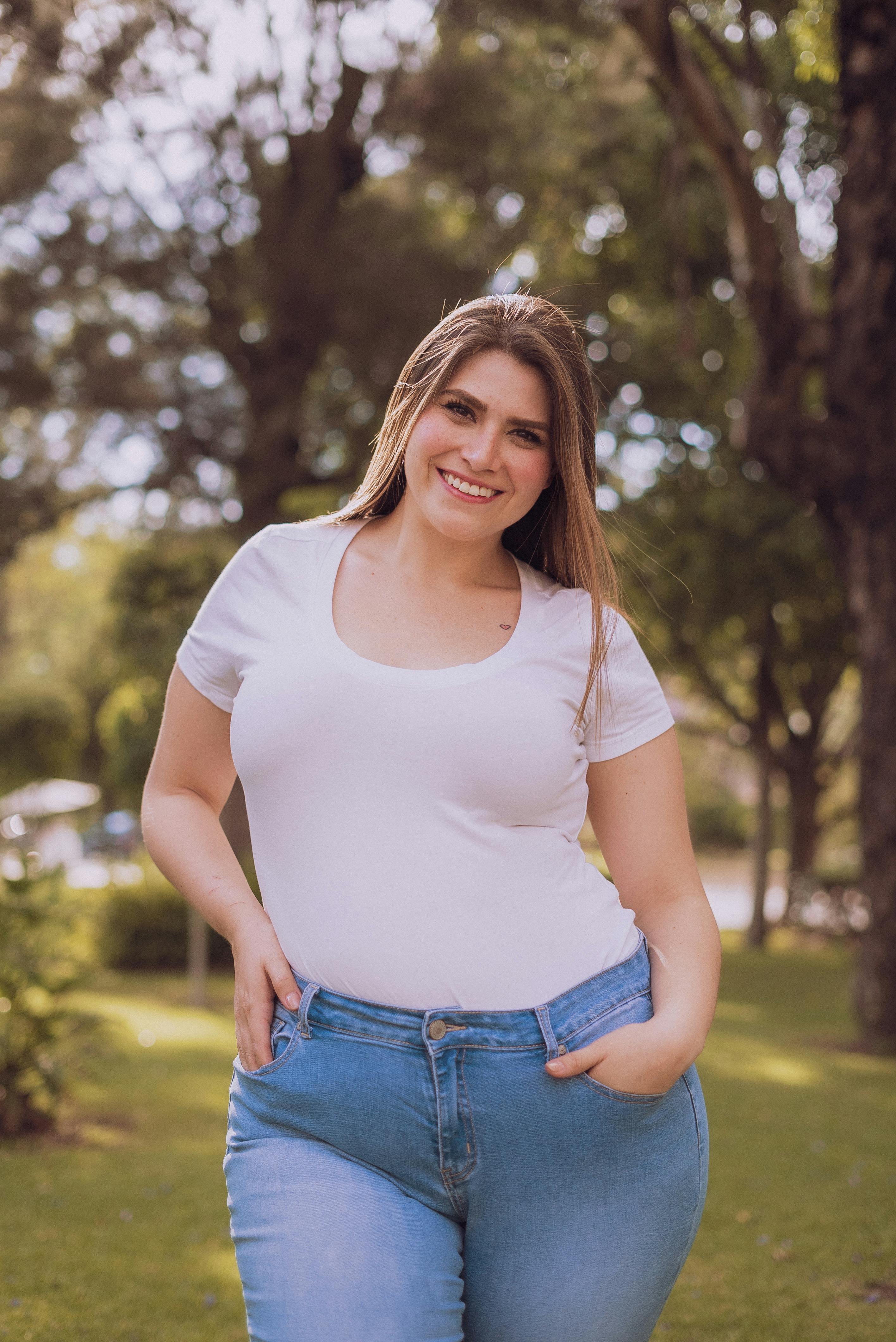 Eine lächelnde Frau in einem weißen Top und Jeans | Quelle: Pexels
