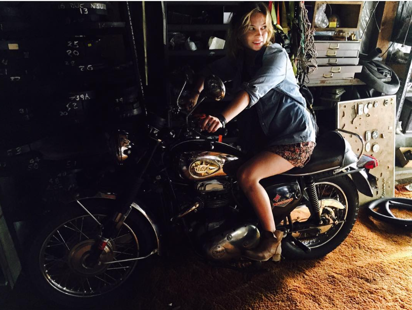 Daveigh Chase lächelt auf einem Motorrad in einer schummrigen Garage – das Foto wurde im September 2015 geteilt, etwa ein Jahrzehnt vor ihrem Tod im Alter von 35 Jahren. | Quelle: Instagram/daveighc
