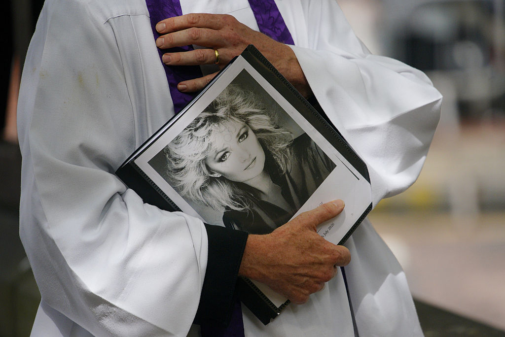 Ein Geistlicher mit einem Bild von Bonnie Tyler vor ihrer Beerdigung in der Swansea Minster. | Quelle: Getty Images