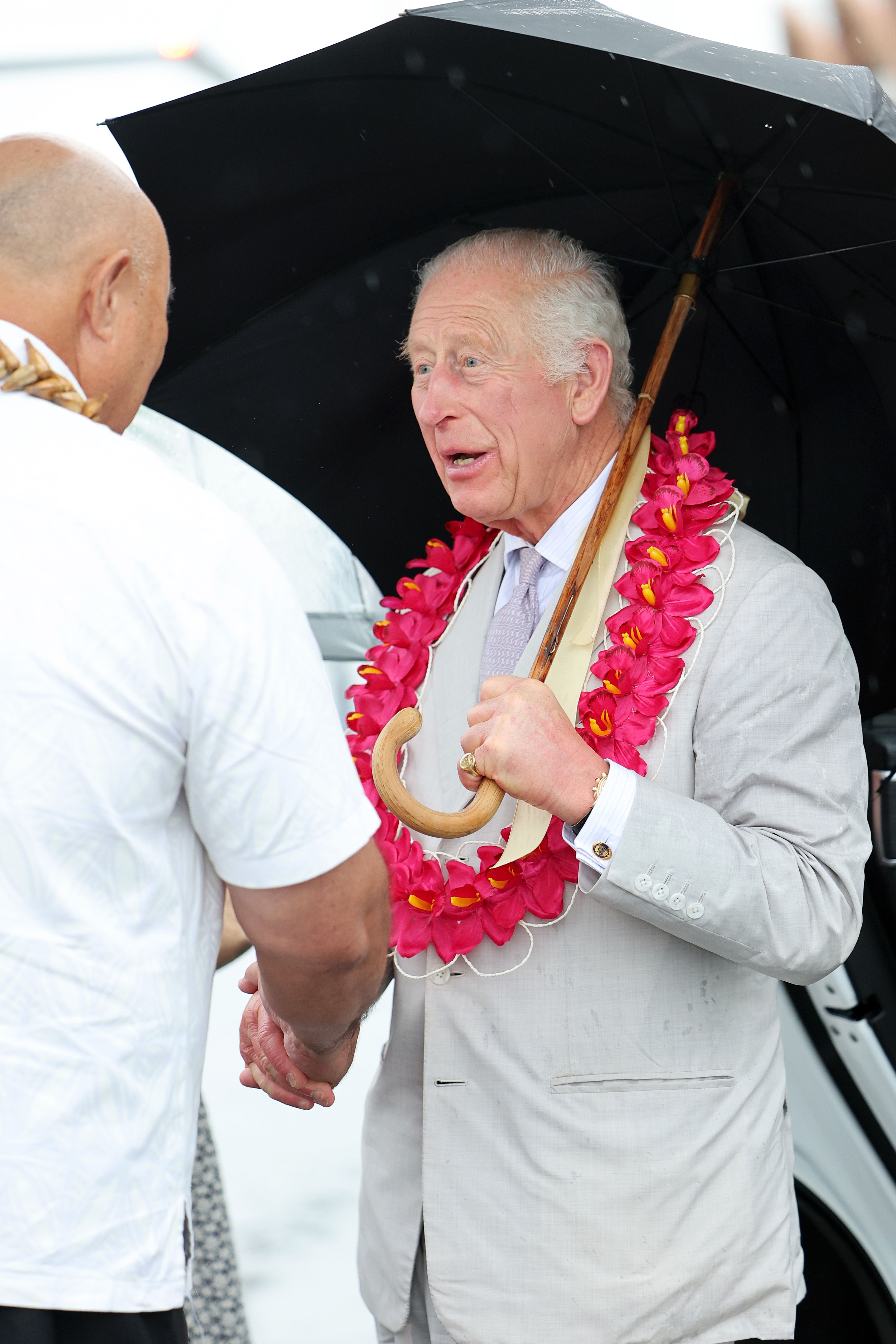 König Karl III. im Gespräch mit einem Samoaner, bevor er nach der Verabschiedung in den Jet der Royal Australian Air Force steigt. | Quelle: Getty Images