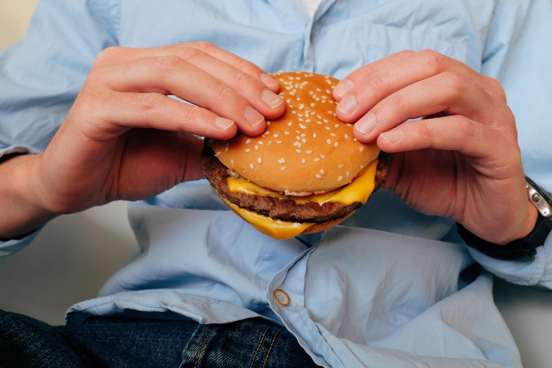 Nahaufnahme eines Mannes, der einen Burger hält | Quelle: Pexels
