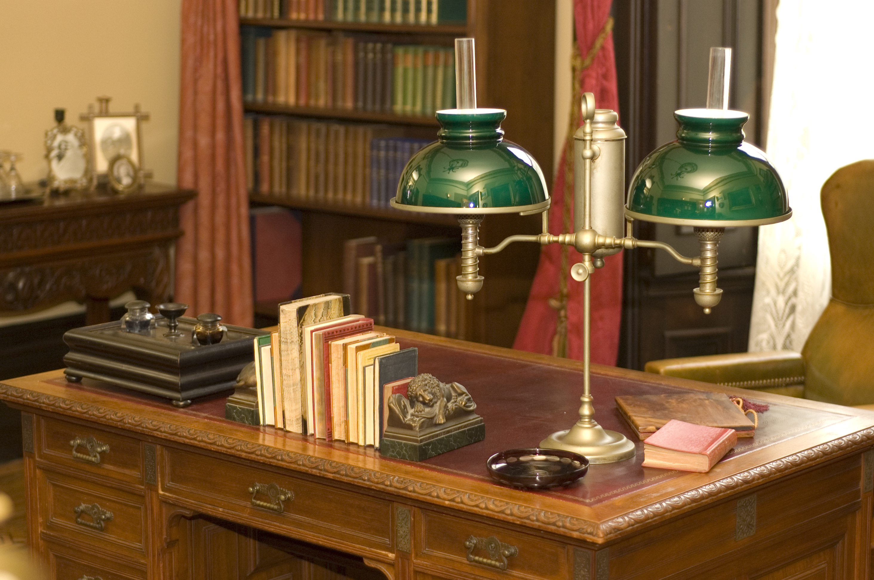 Eine klassische Öllampe und Bücher auf einem antiken Bürotisch | Quelle: Shutterstock