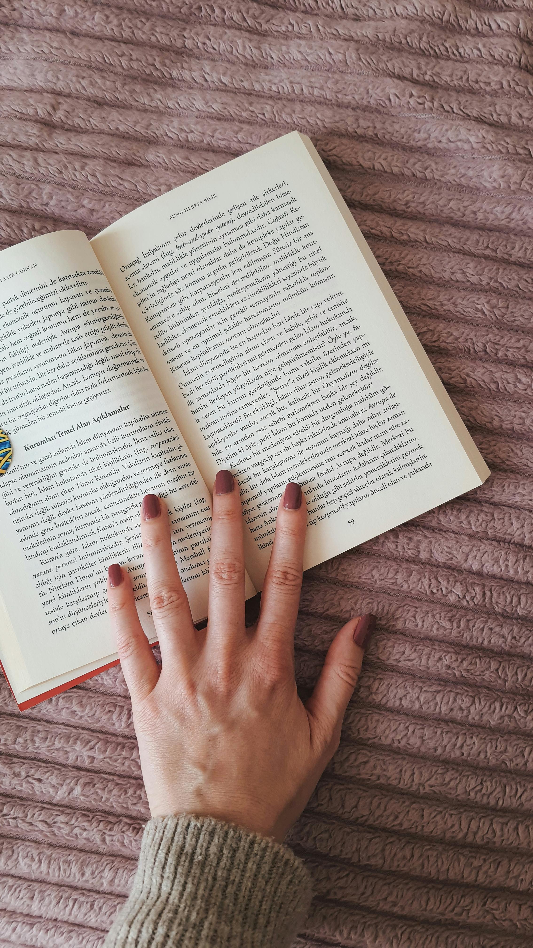 Die Hand einer Frau über einem Buch | Quelle: Pexels