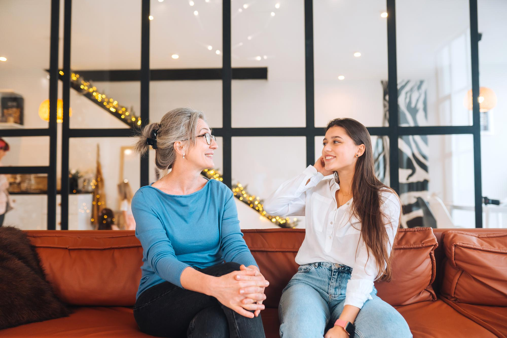 Ein Mutter-Tochter-Duo unterhält sich auf einem Sofa sitzend | Quelle: Freepik