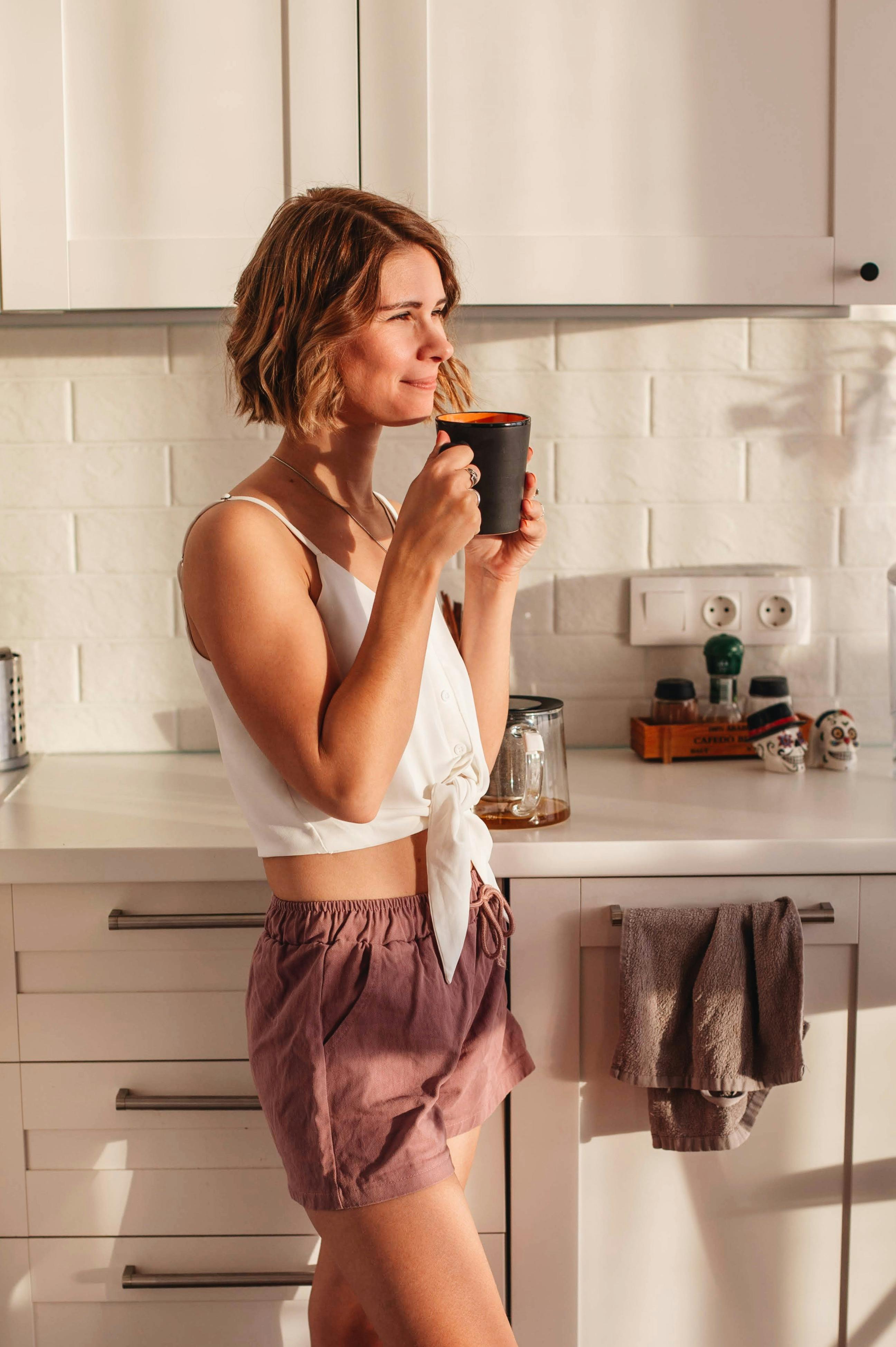 Eine Frau, die ihr Haus mit einer Tasse Kaffee genießt | Quelle: Pexels