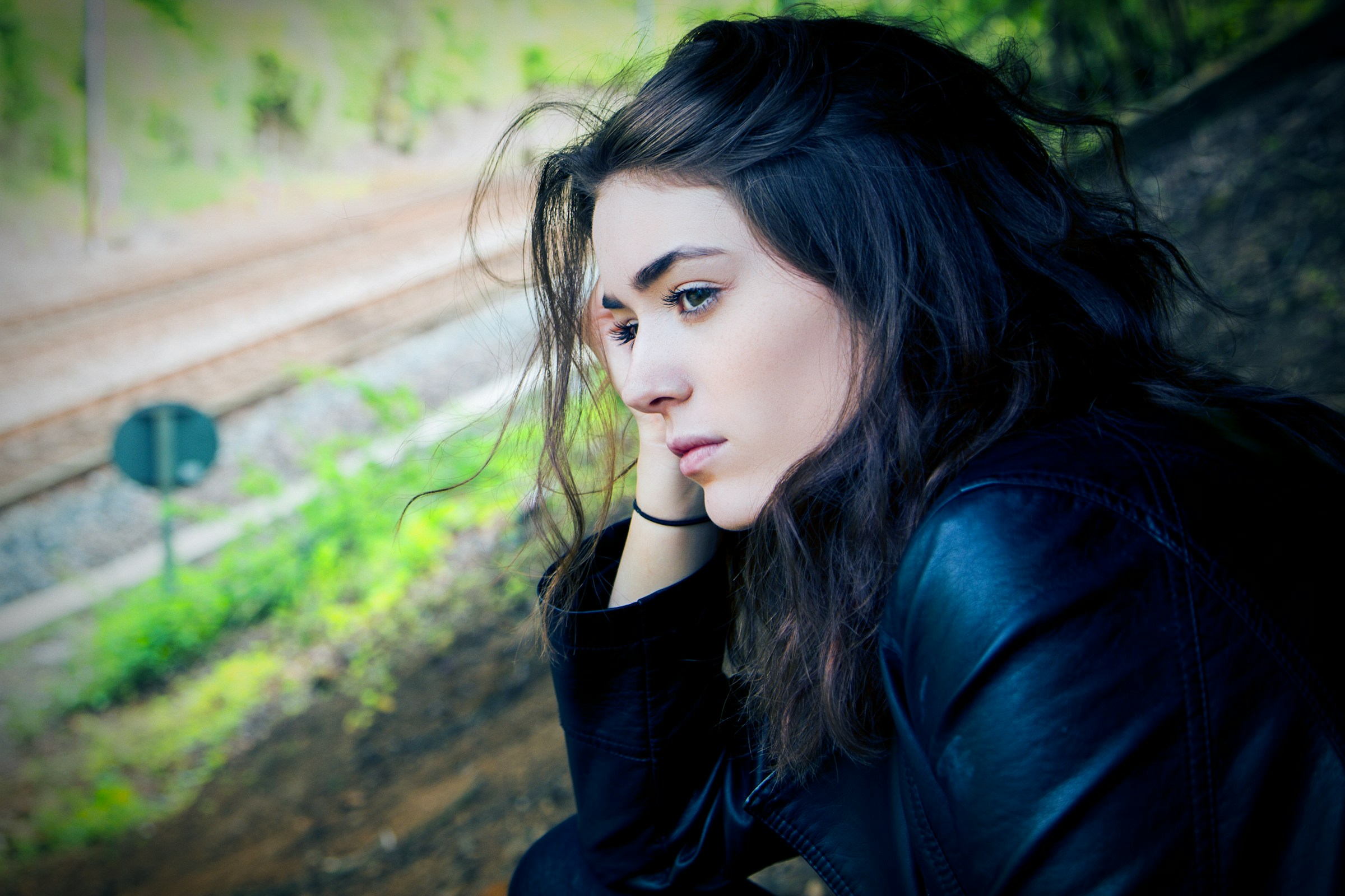 Eine nachdenkliche junge Frau, die tagsüber im Freien sitzt | Quelle: Unsplash