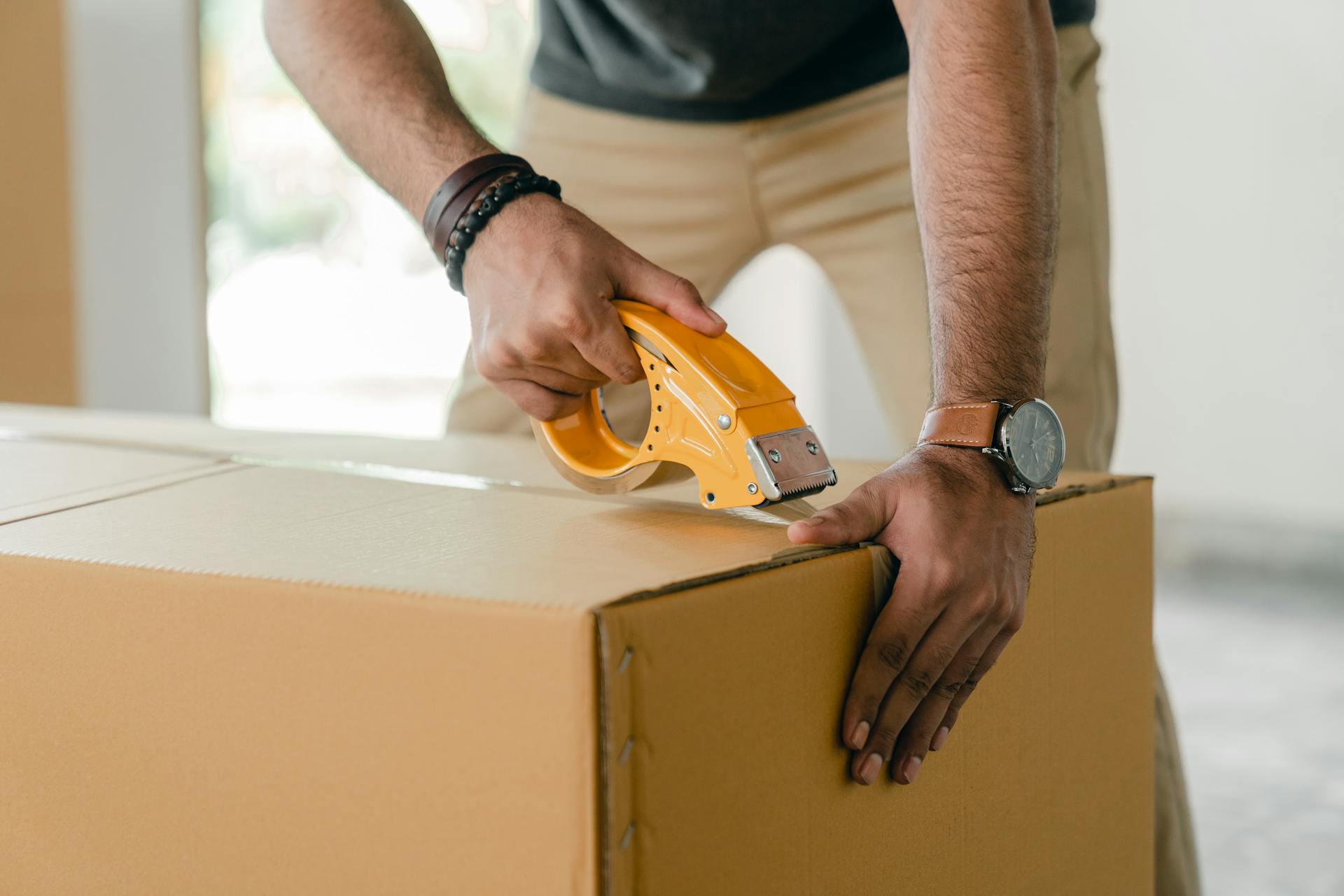 Ein Mann packt Kleidung in eine Kiste | Quelle: Pexels
