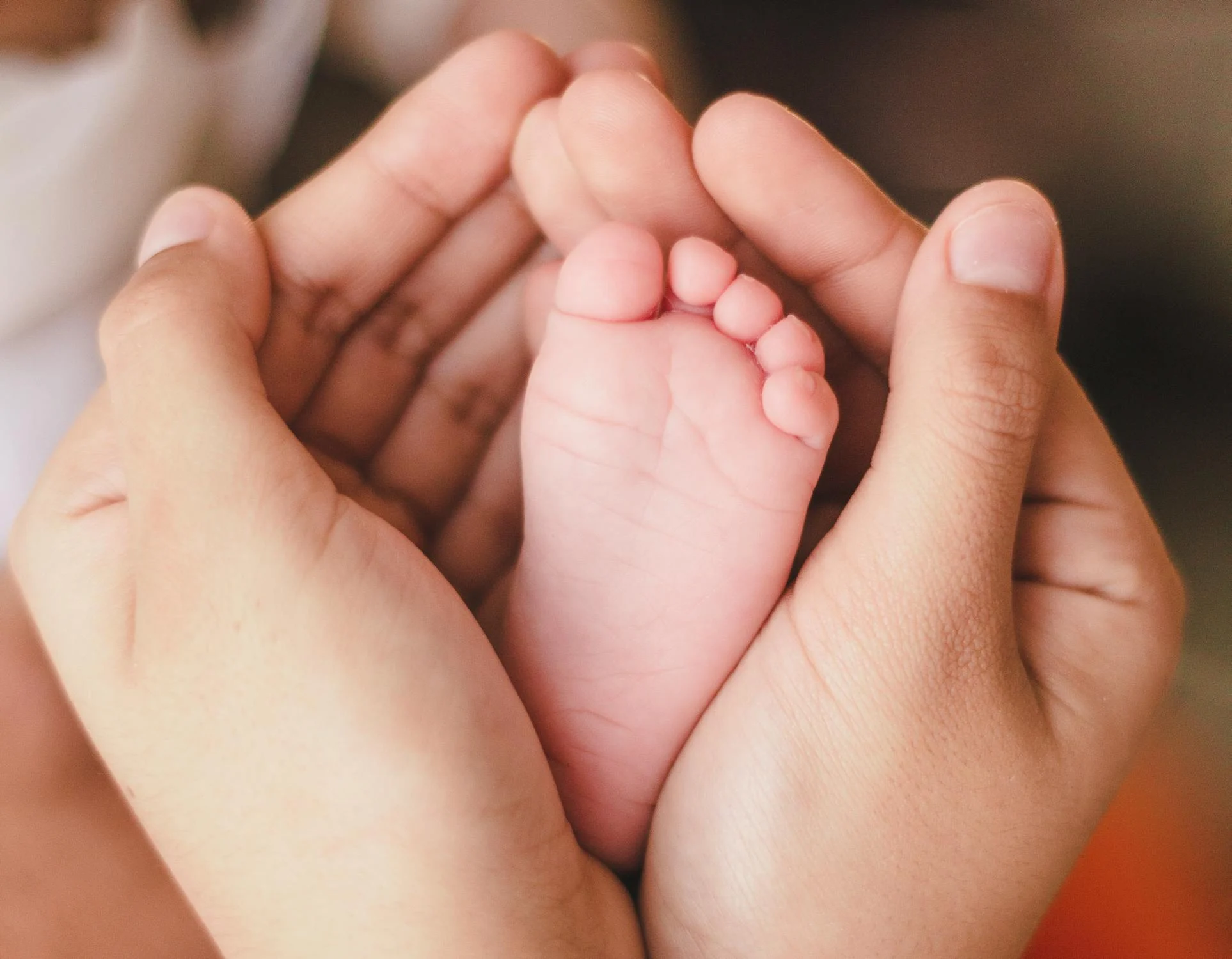 Eine Frau, die den Fuß eines Babys hält | Quelle: Pexels