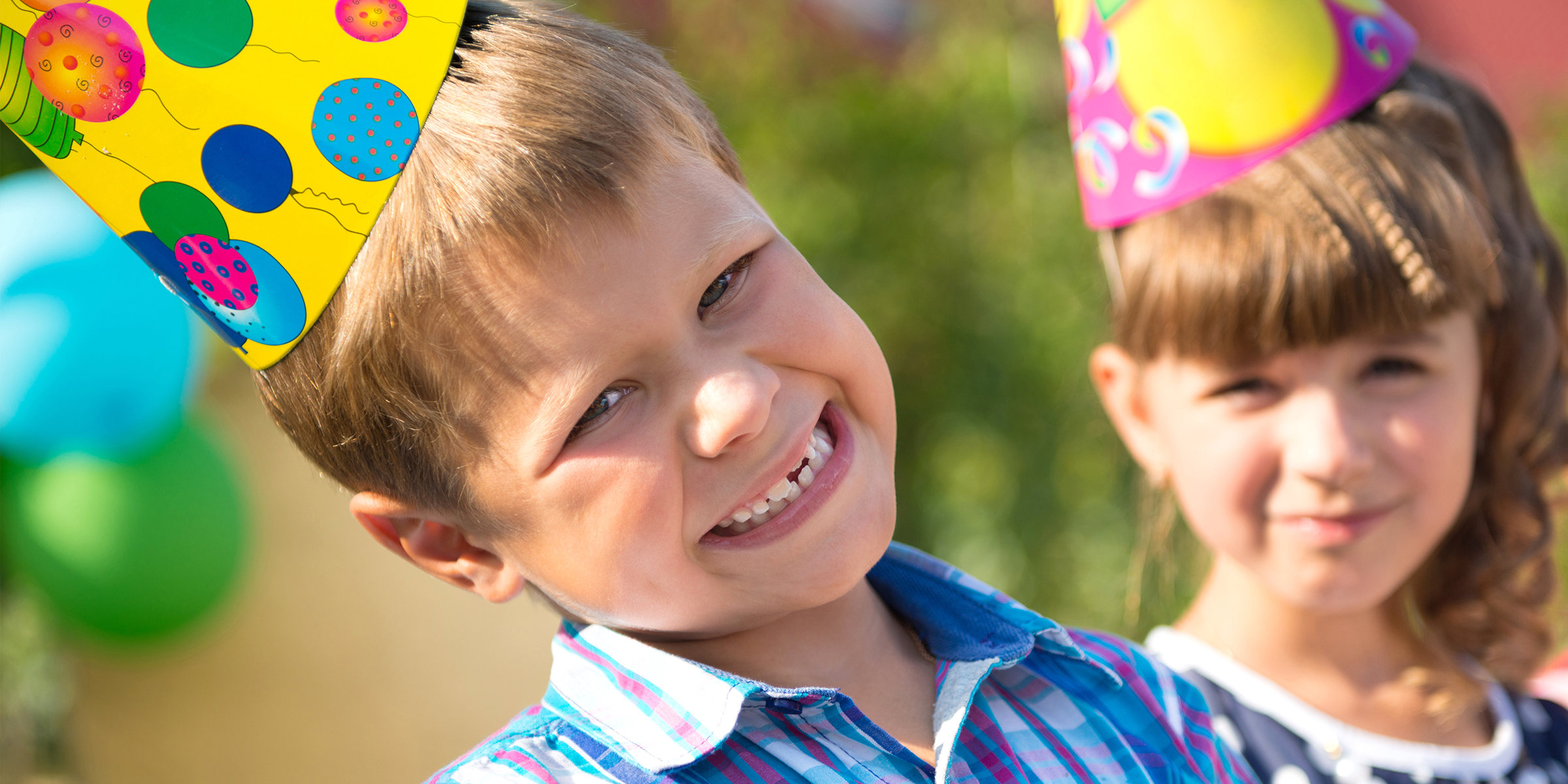 Kinder genießen einen fröhlichen Moment mit Partyhüten und Sonnenschein | Quelle: Shutterstock