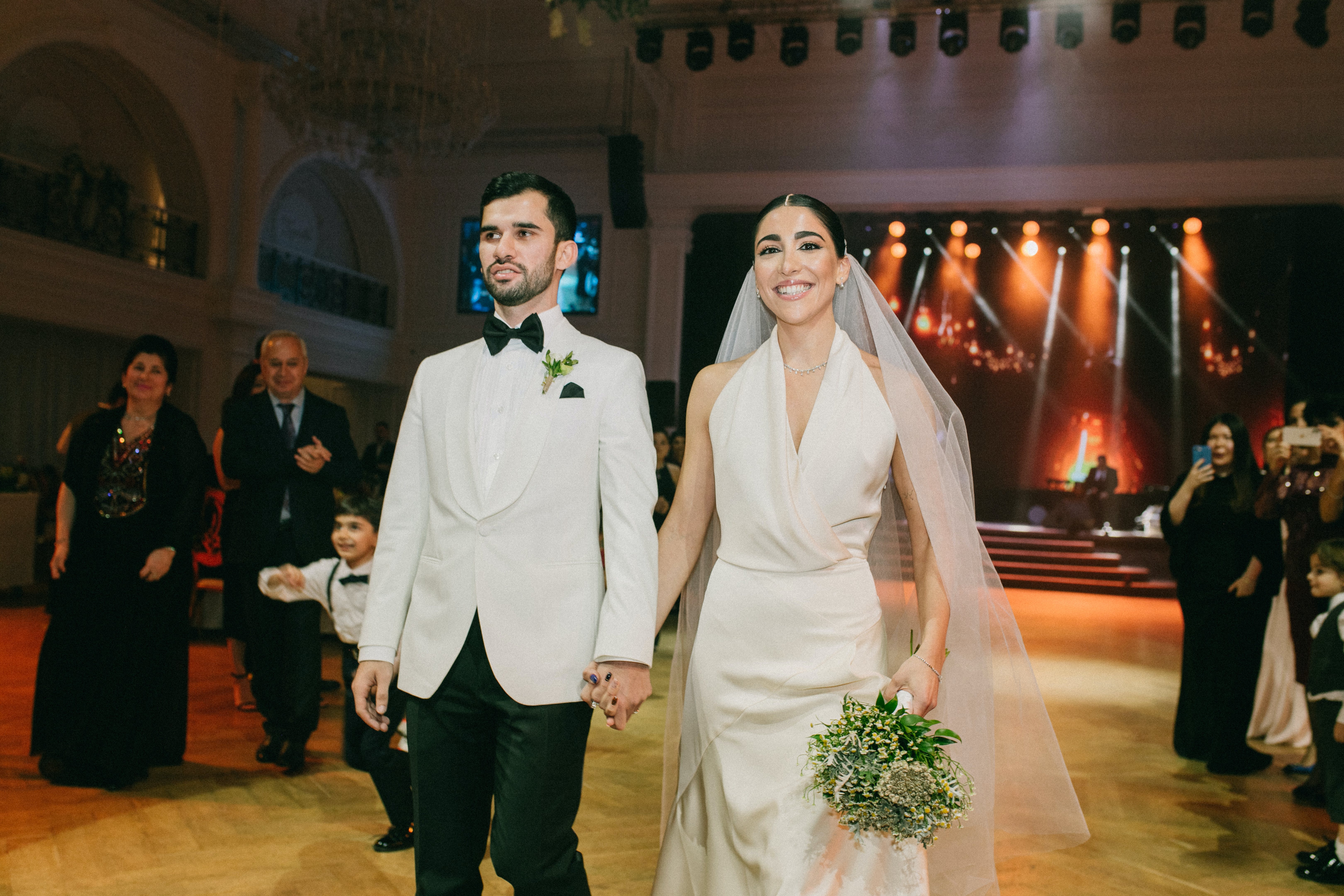 Der Bräutigam und die Braut gehen Hand in Hand am Hochzeitsort | Quelle: Pexels