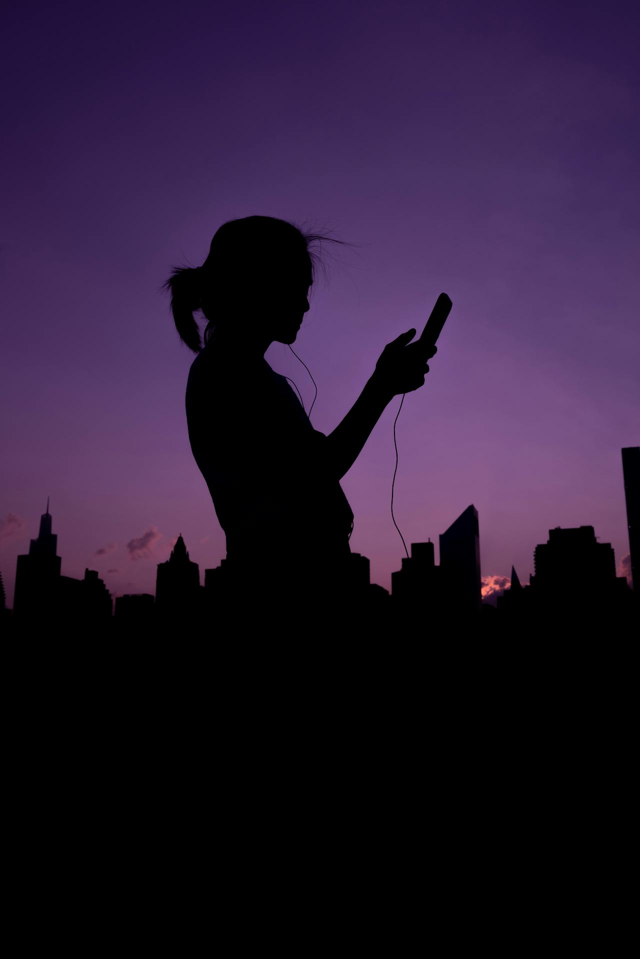 Silhouette einer Frau, die ihr Telefon hält | Quelle: Pexels