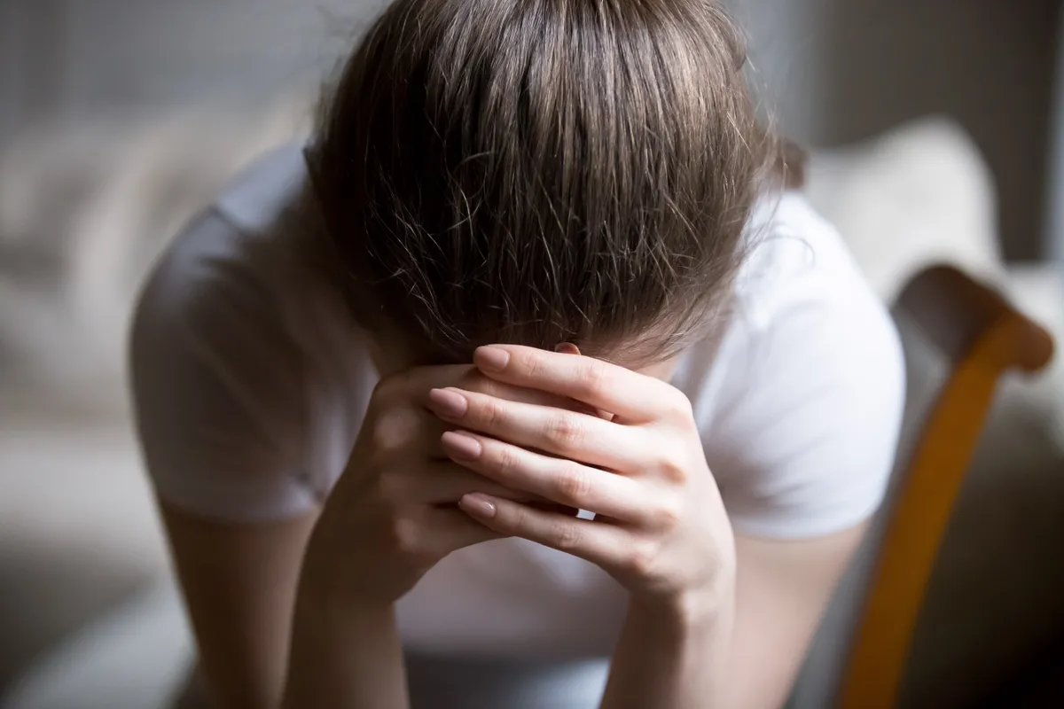 Eine depressive junge Frau, die zu Hause weint | Quelle: Shutterstock