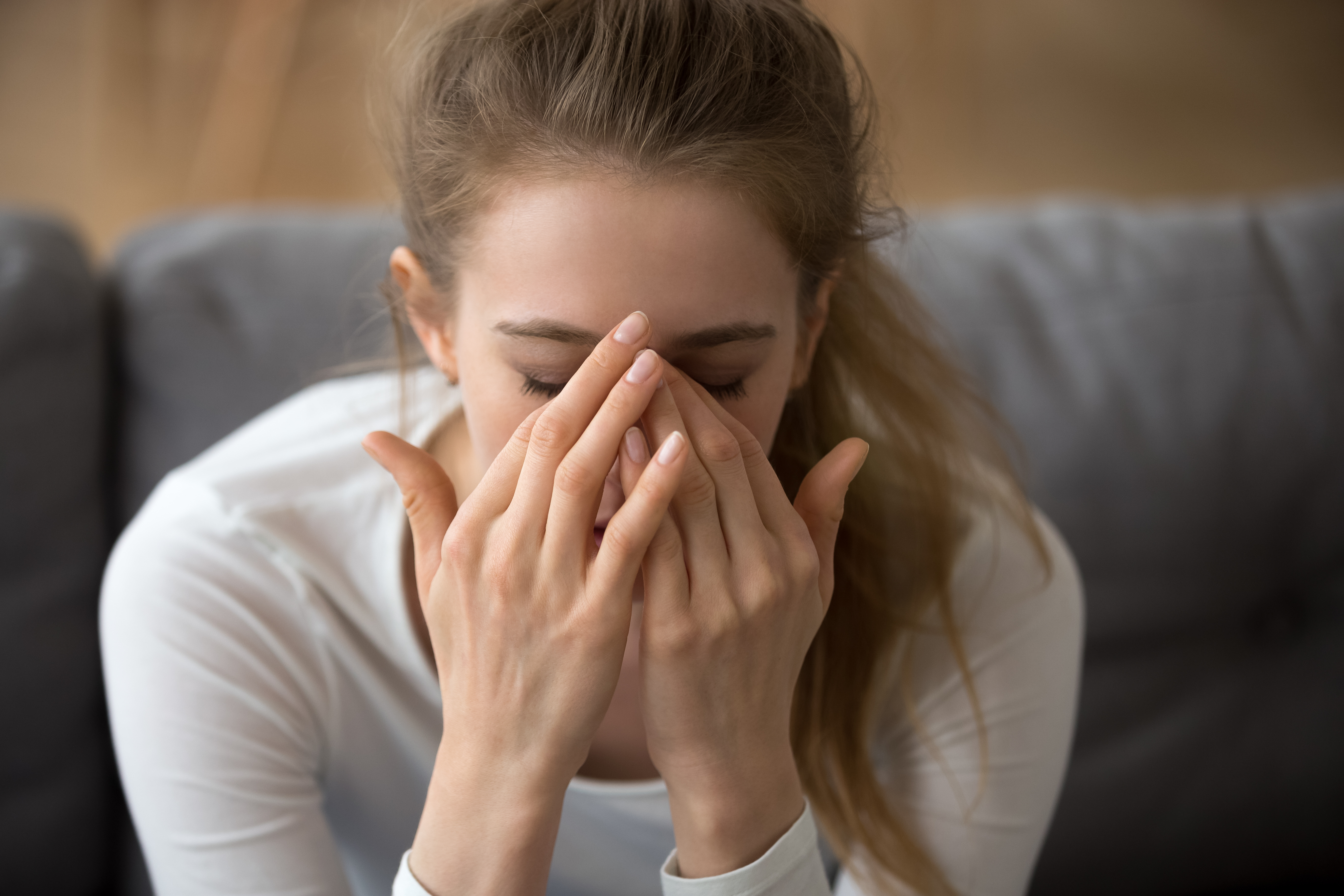 Ein junges Mädchen, das sein Gesicht mit den Händen bedeckt | Quelle: Shutterstock