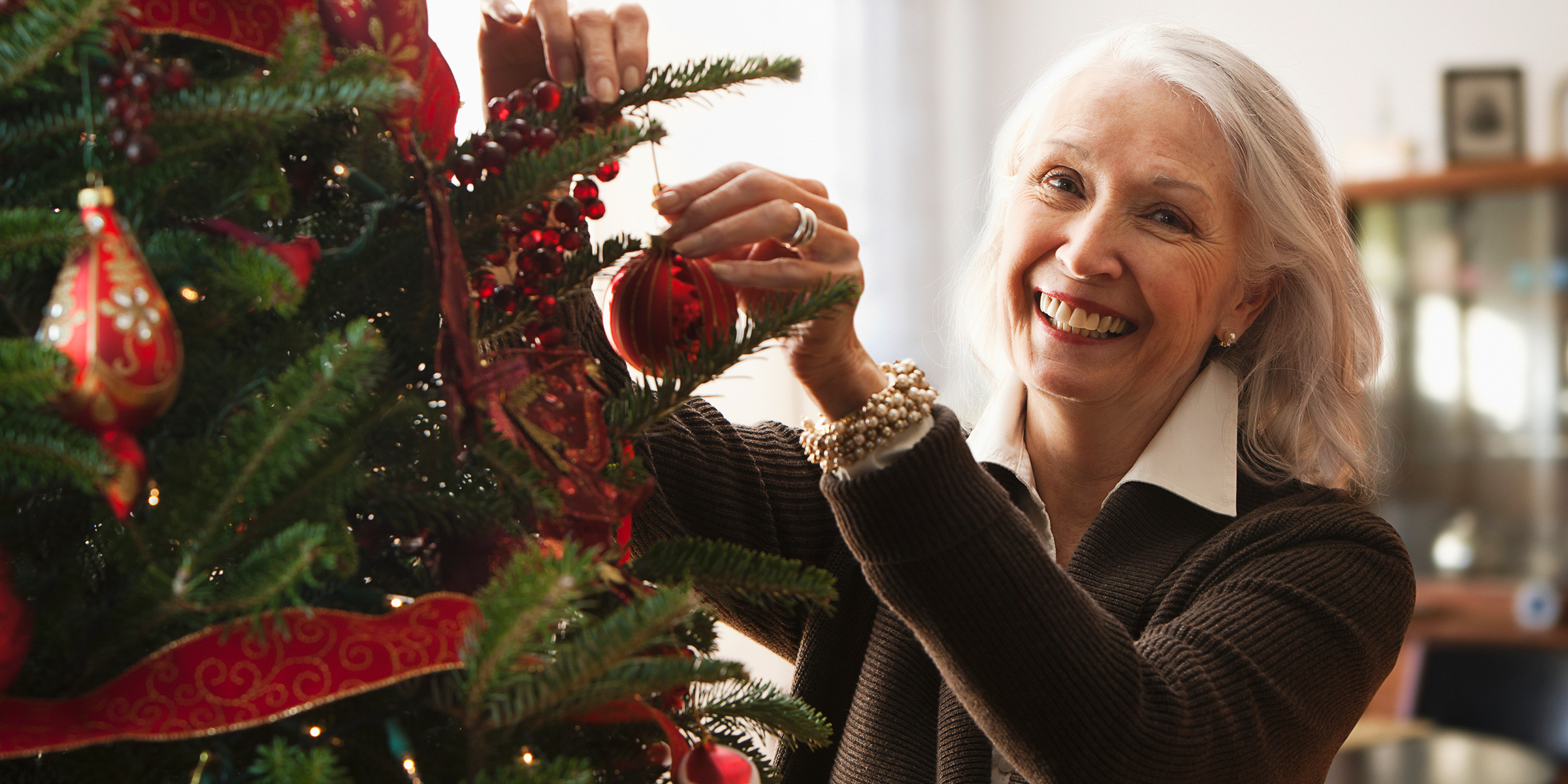 Eine Frau schmückt einen Weihnachtsbaum | Quelle: Getty Images