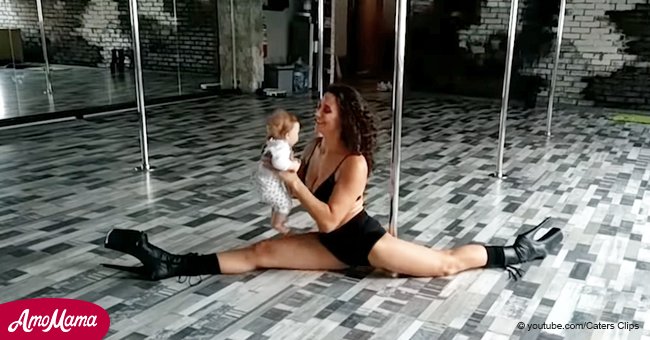 Ein beeindruckender Poledance der Mutter mit ihrem Baby in den Armen