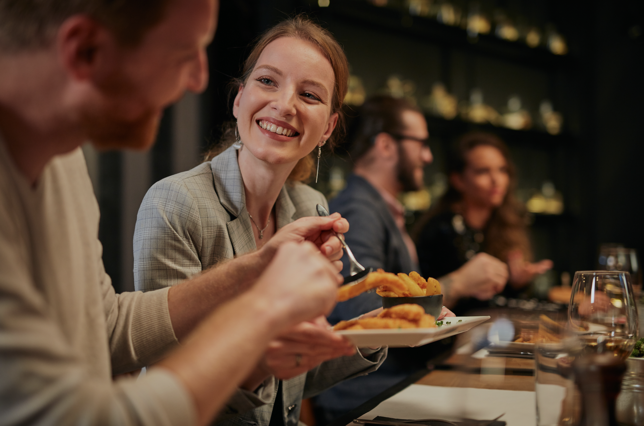 Eine junge Frau lächelt dem Mann im Restaurant zu | Quelle: Shutterstock