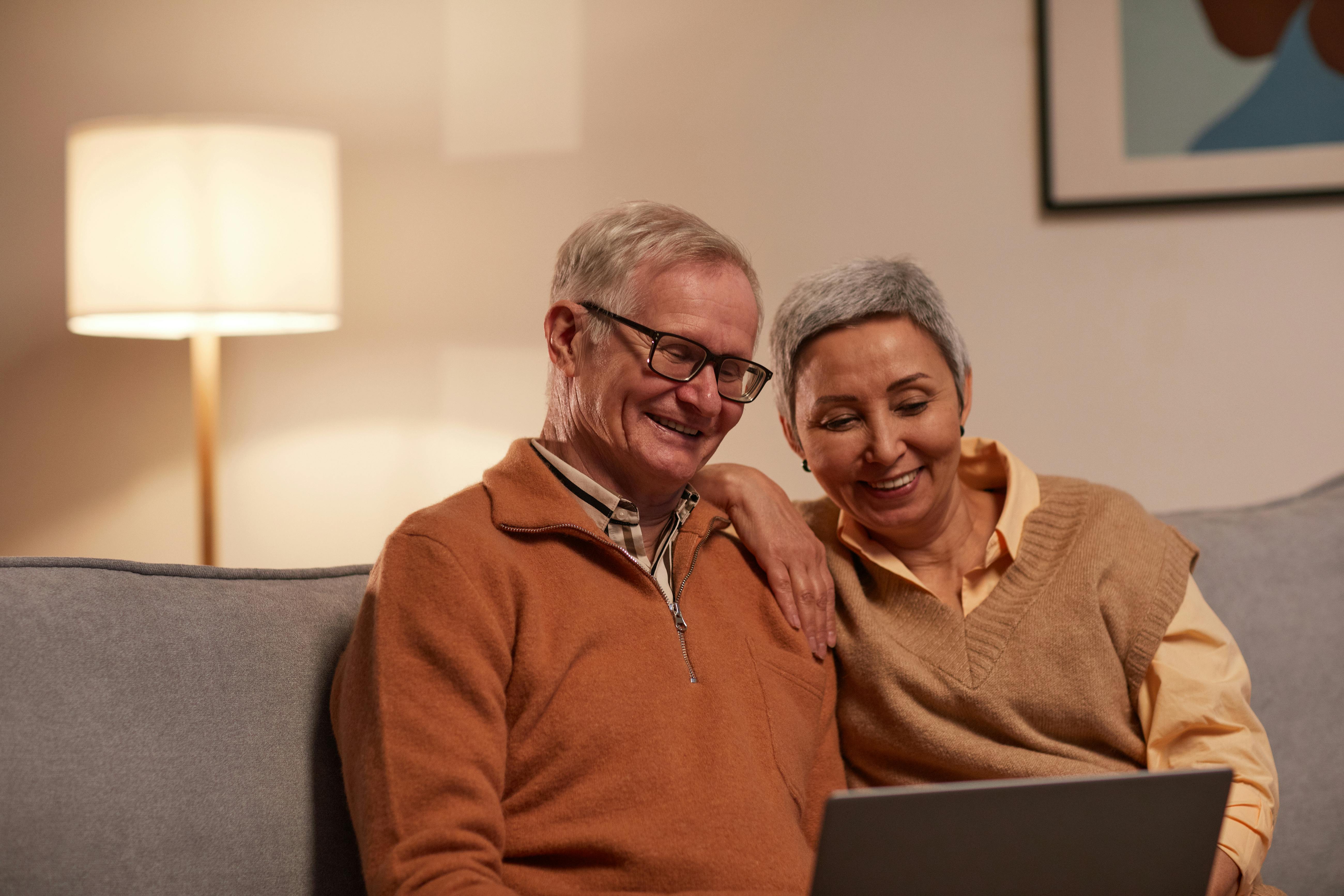 Ein glückliches Paar, das sich etwas auf einem Laptop ansieht | Quelle: Pexels