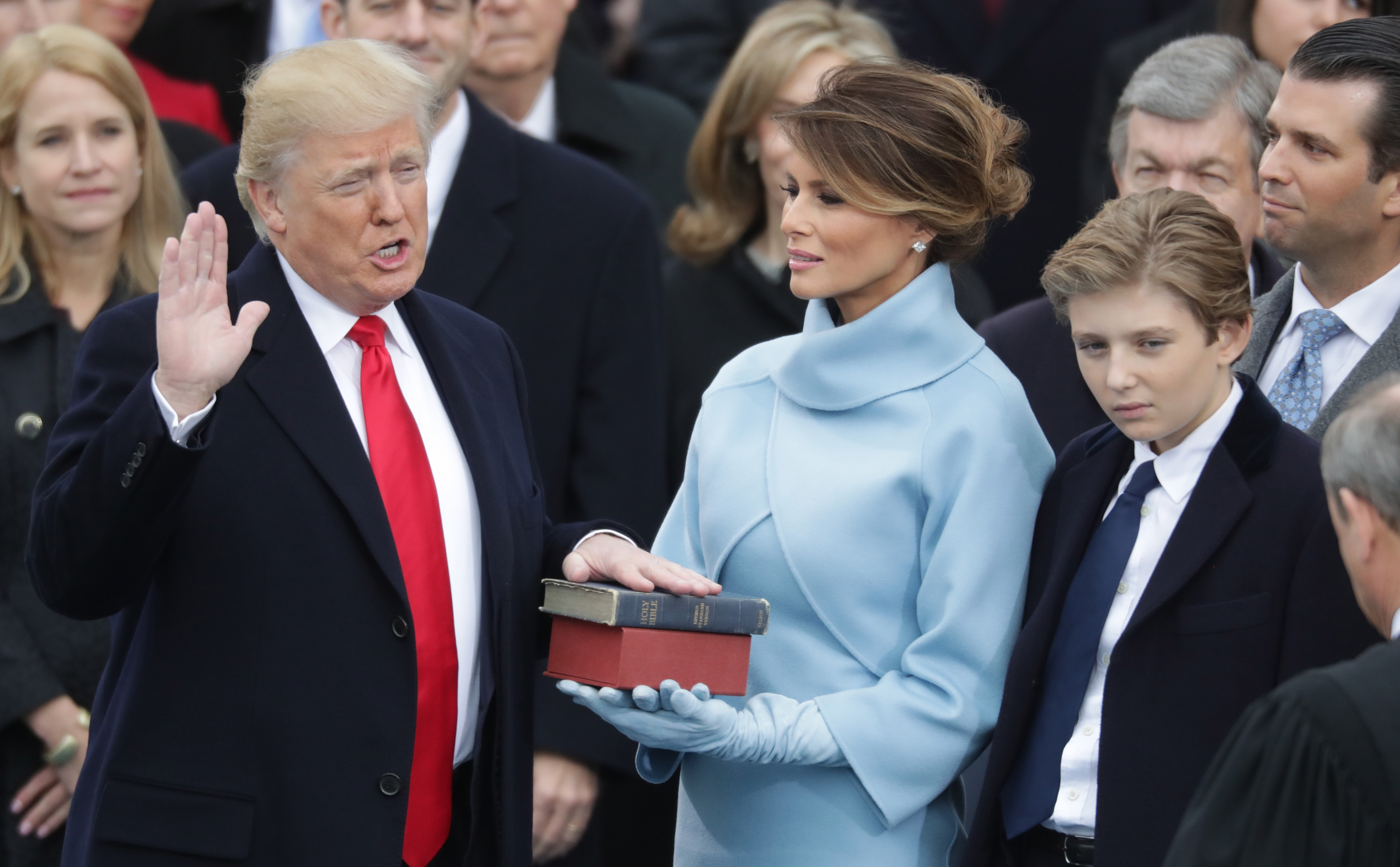 Donald Trump legt den Amtseid ab, während Melania Trump die Bibel hält und Barron Trump zusieht, an der Westfront des US-Kapitols in Washington, DC, am 20. Januar 2017 | Quelle: Getty Images