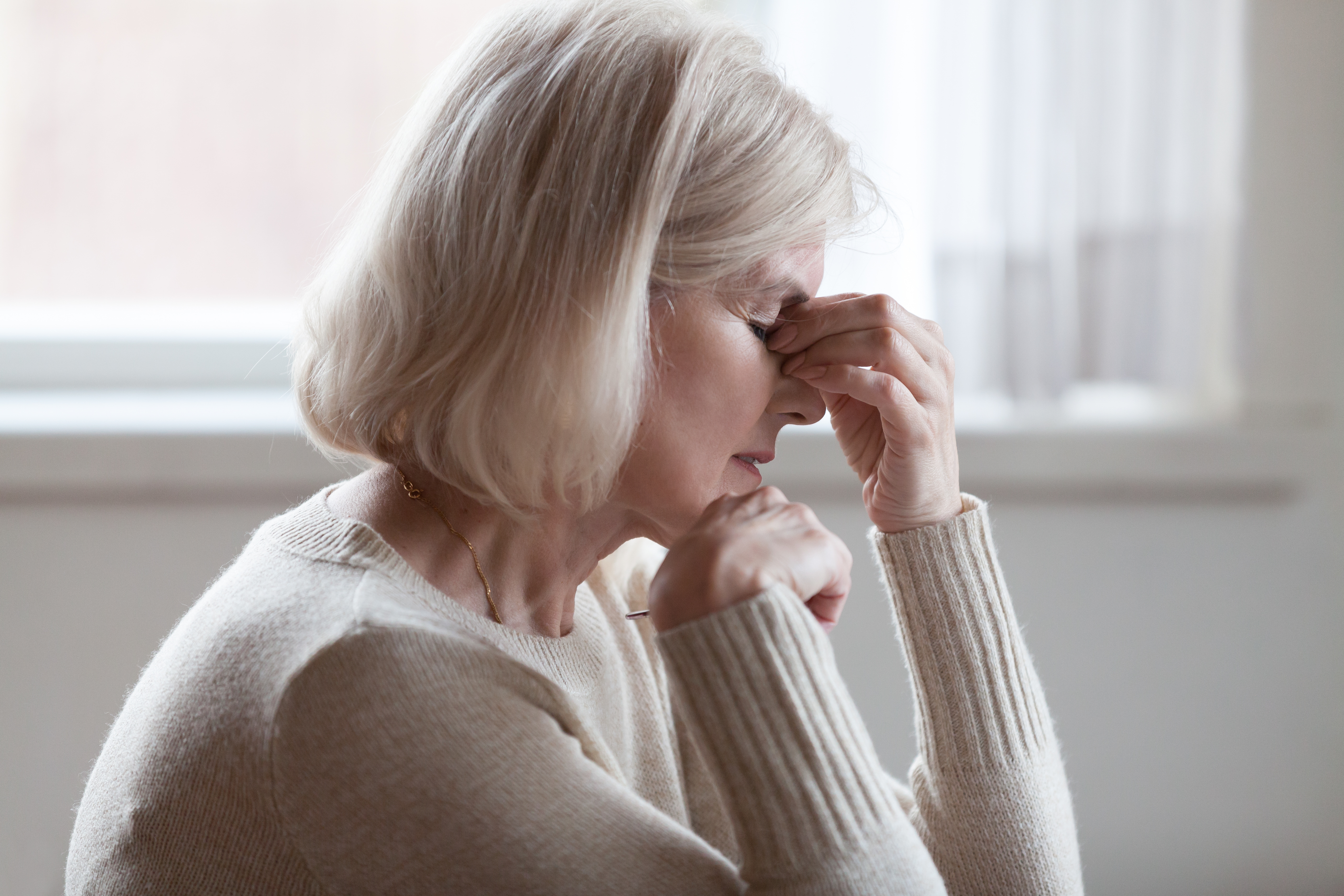 Eine gestresste Frau mittleren Alters.│Quelle: Shutterstock