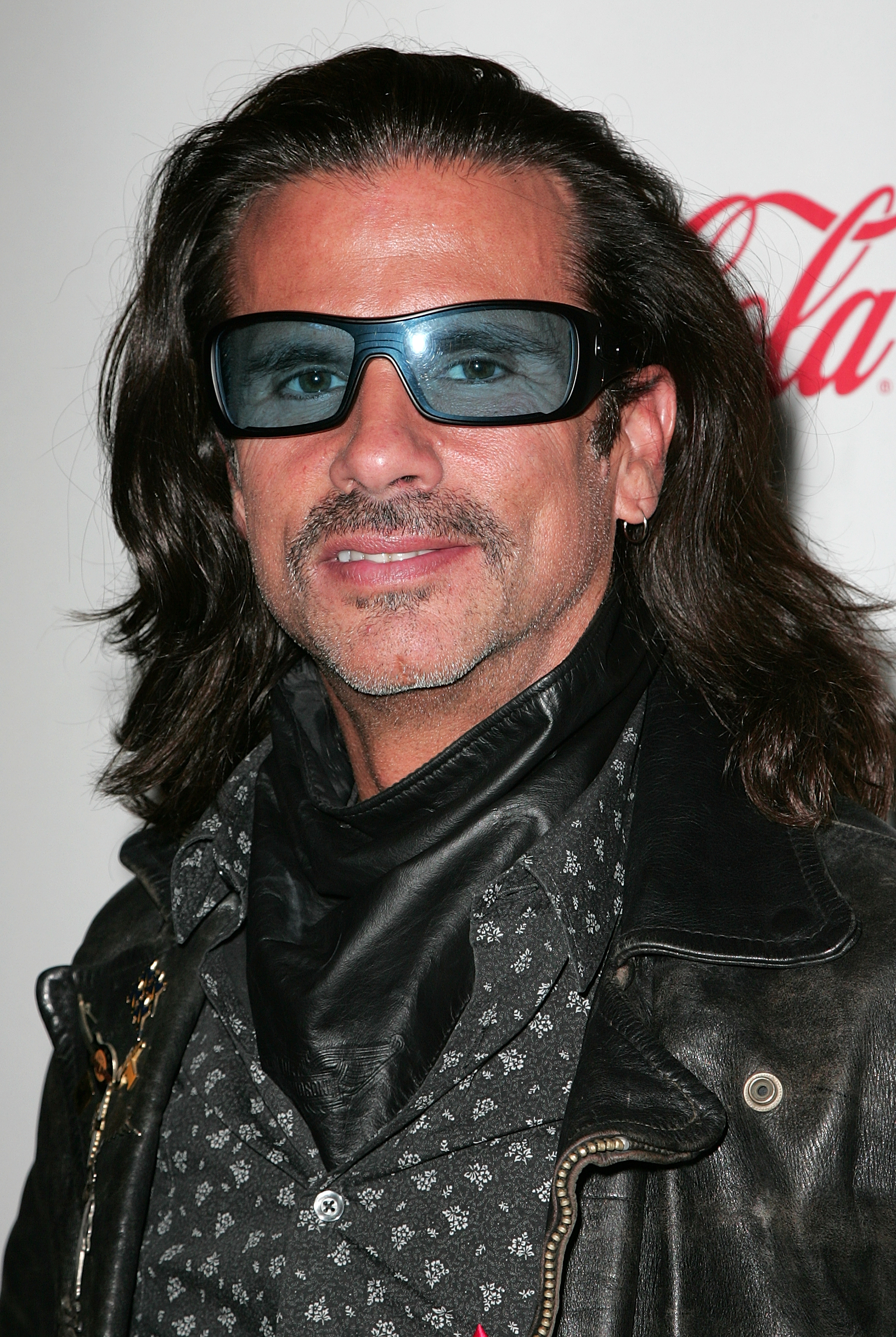 Lorenzo Lamas sorgt bei der Hollywood Christmas Parade 2009 im Roosevelt Hotel in Hollywood, Kalifornien, am 29. November 2009 für einen coolen Biker-Look. Mit einem dezenten Lächeln und gepflegtem Bart ergänzt der Schauspieler seinen typischen schulterlangen dunklen Haarschopf mit einer blau getönten Wrap-Around-Sonnenbrille, einem dunklen Leder-Halswärmer, einem gemusterten Hemd und einer abgenutzten Lederjacke. | Quelle: Getty Images