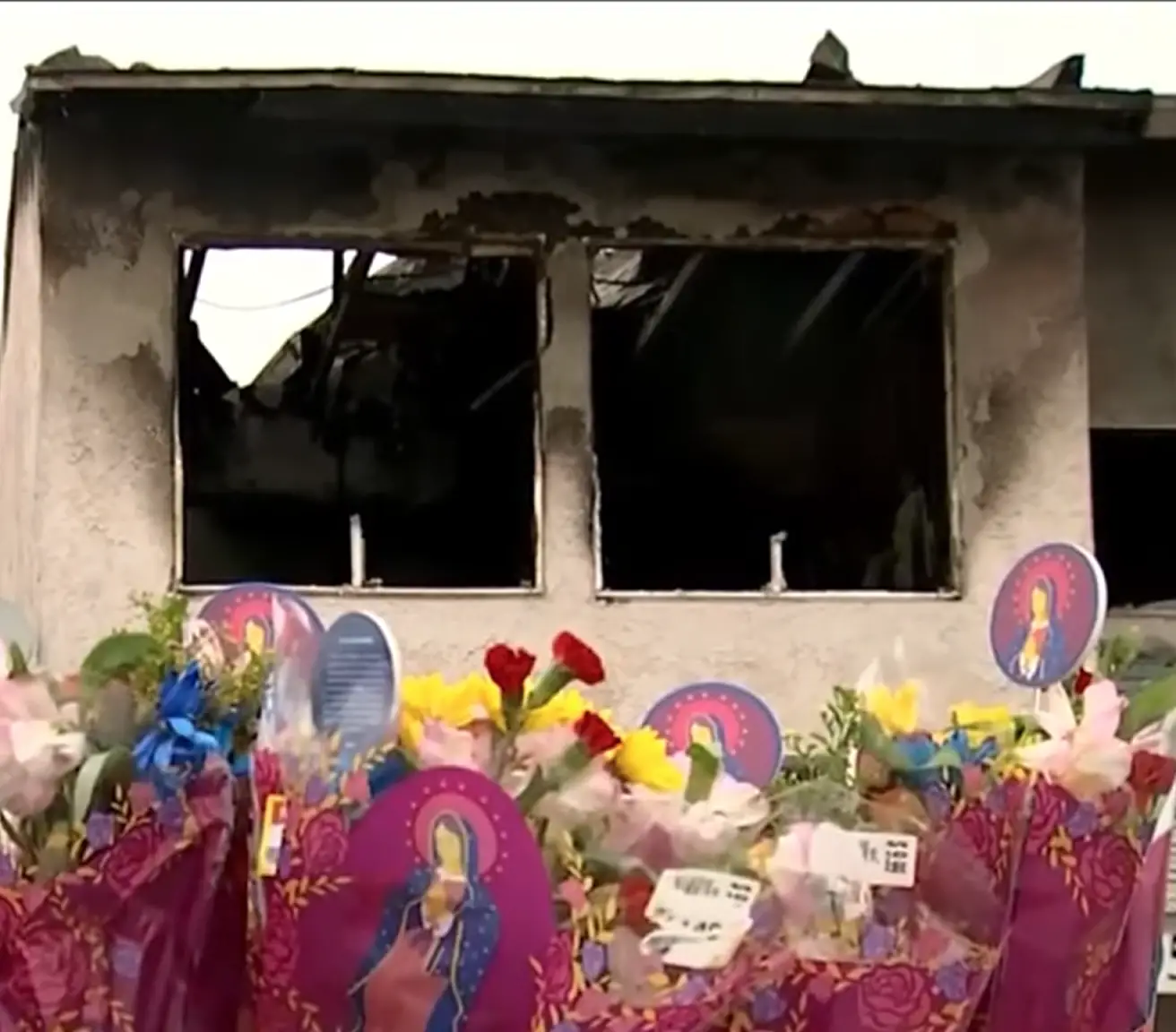 Blumen und Stofftiere rund um das Haus, das in Brand geriet und fünf Kinder tötete | Quelle: Youtube.com/AZFamily | Arizona News