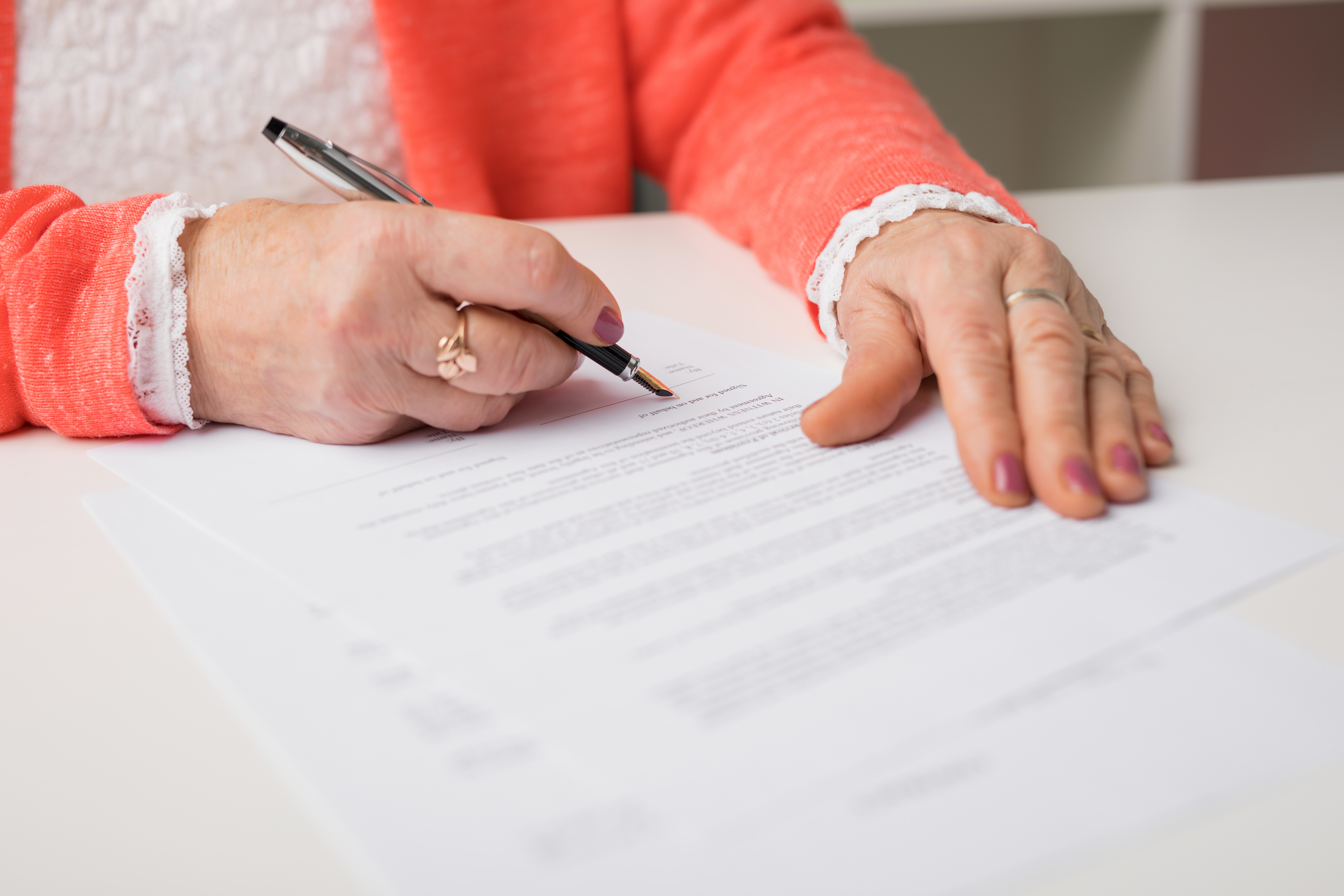 Ältere Frau beim Unterschreiben eines Dokuments | Quelle: Shutterstock