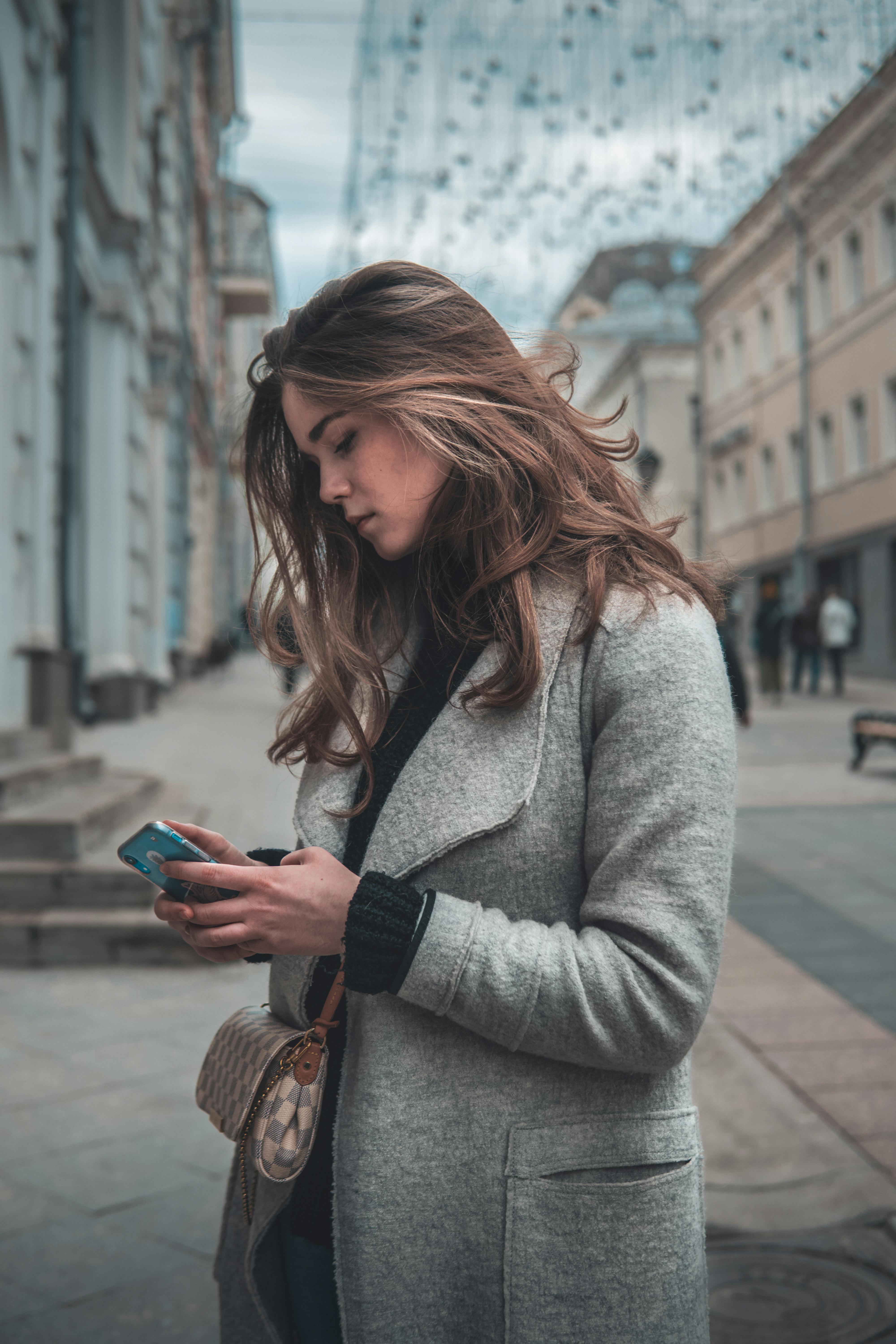 Eine Frau auf der Straße, die ihr Telefon benutzt | Quelle: Pexels