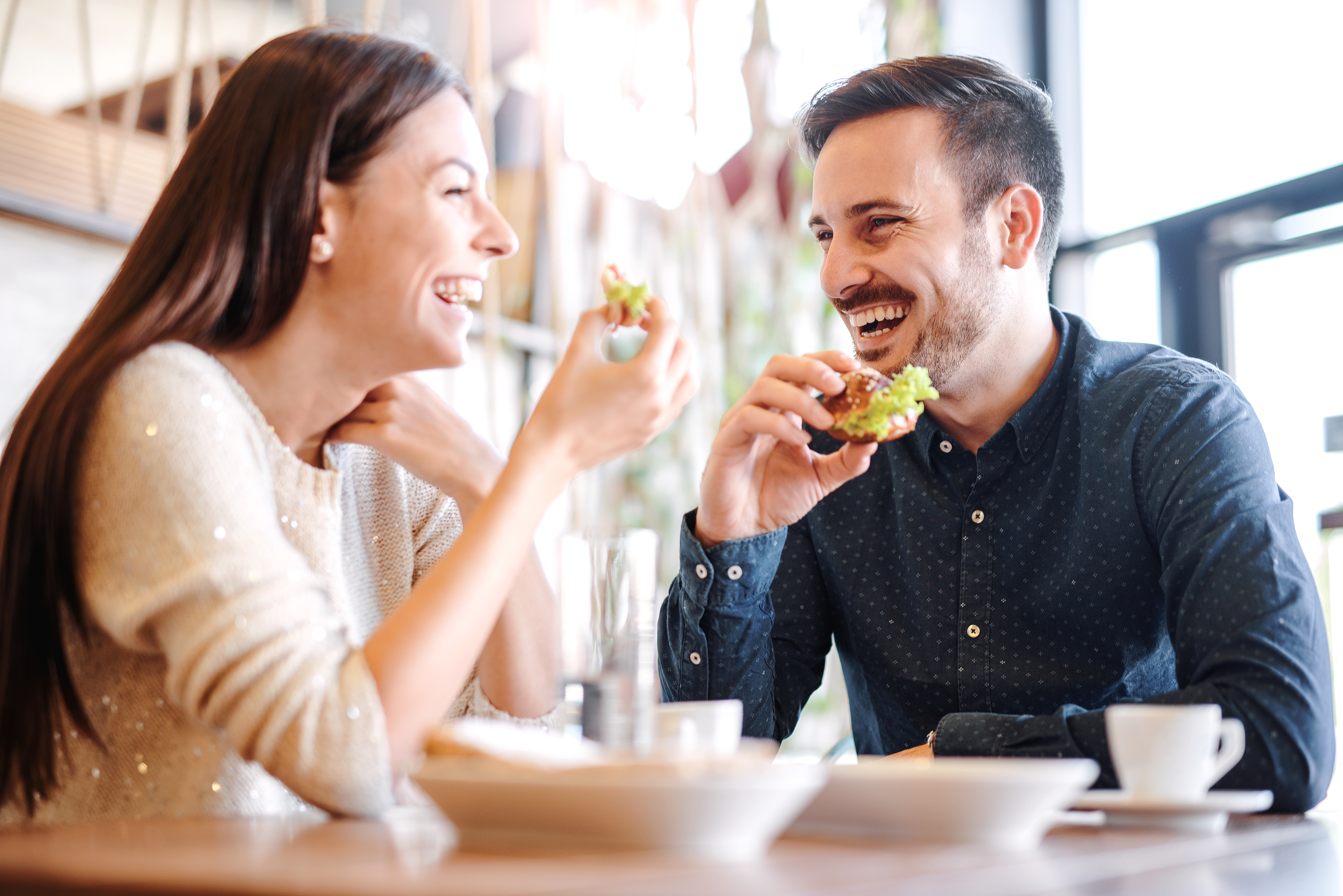 Ein lachendes Paar bei einer gemeinsamen Mahlzeit | Quelle: Shutterstock