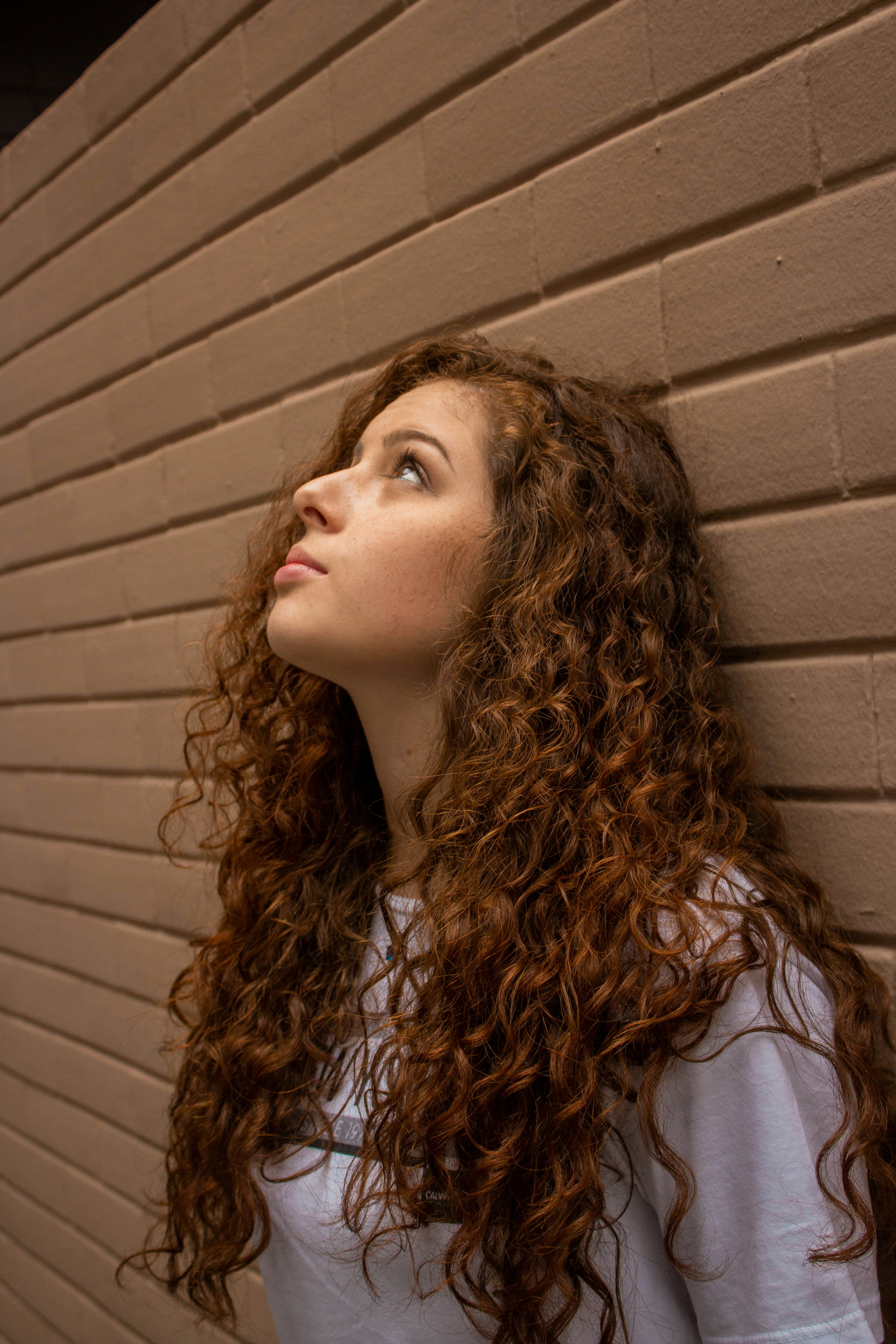 Eine junge Frau lehnt an einer Wand | Quelle: Unsplash