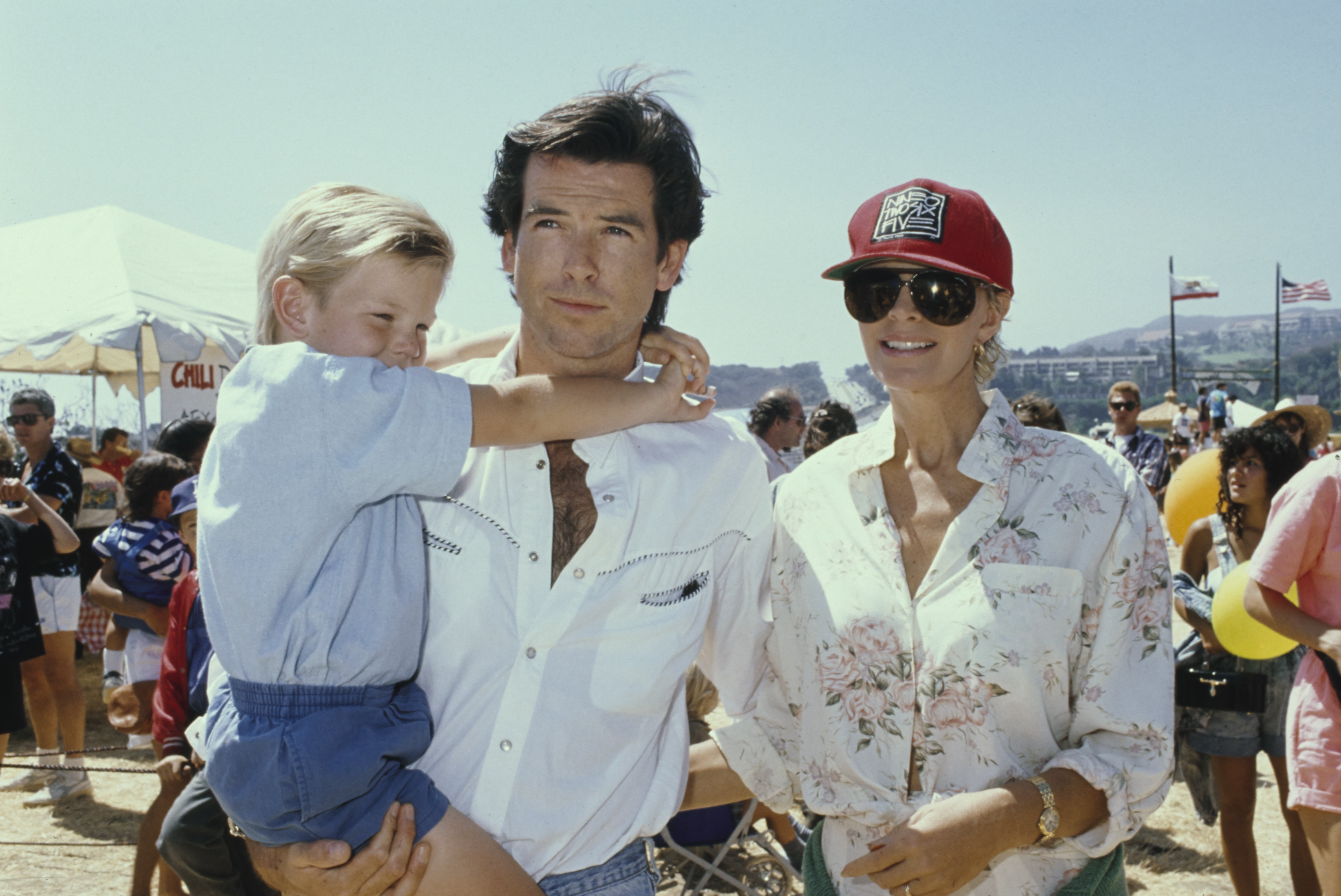 Der irische Schauspieler Pierce Brosnan mit seiner Frau, der australischen Schauspielerin Cassandra Harris, und seinem Sohn Sean beim 8. jährlichen Malibu Kiwanis Chili Cook-off Carnival & Fair im Civic Center Area in Malibu, Kalifornien, am 2. September 1989. | Quelle: Getty Images