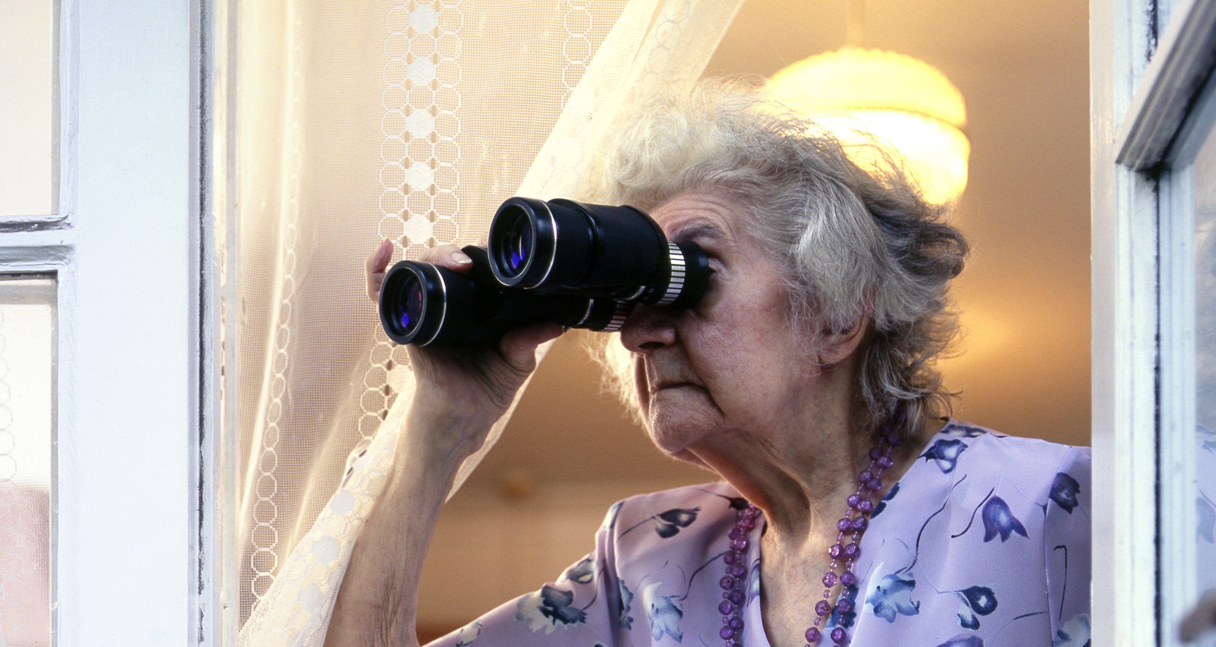 Eine ältere Frau schaut durch ein Fernglas | Quelle: Getty Images