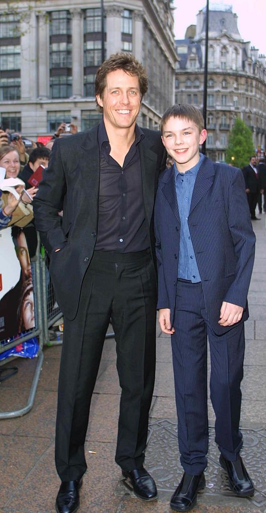 Die Schauspieler Hugh Grant (L) und Nicholas Hoult (R) bei der Londoner Premiere ihres neuesten Films "About A Boy" im Empire Leicester Square, London, am 14. April 2002 | Quelle: Getty Images