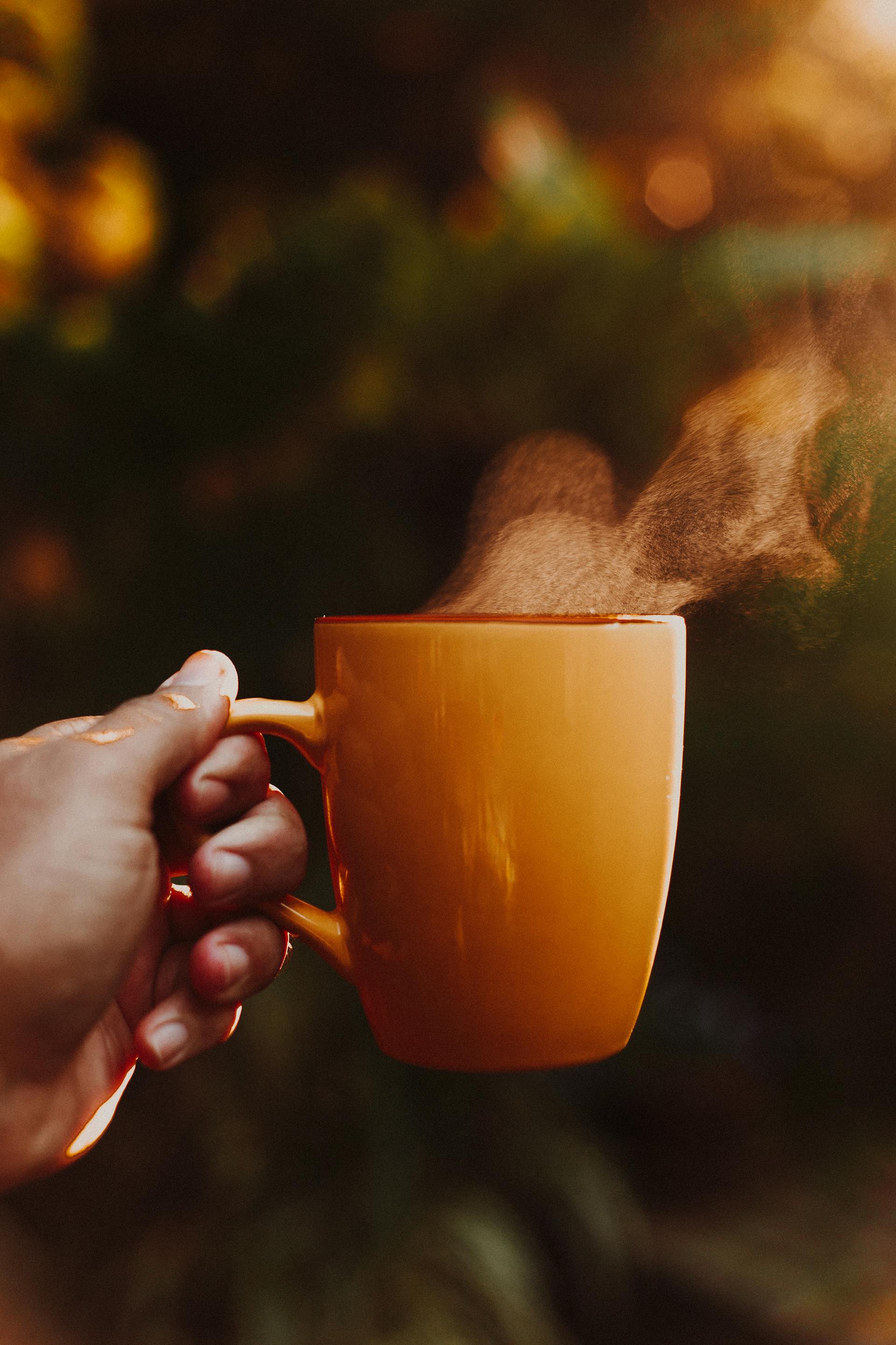 Eine Person mit einer Tasse Kaffee in der Hand | Quelle: Pexels