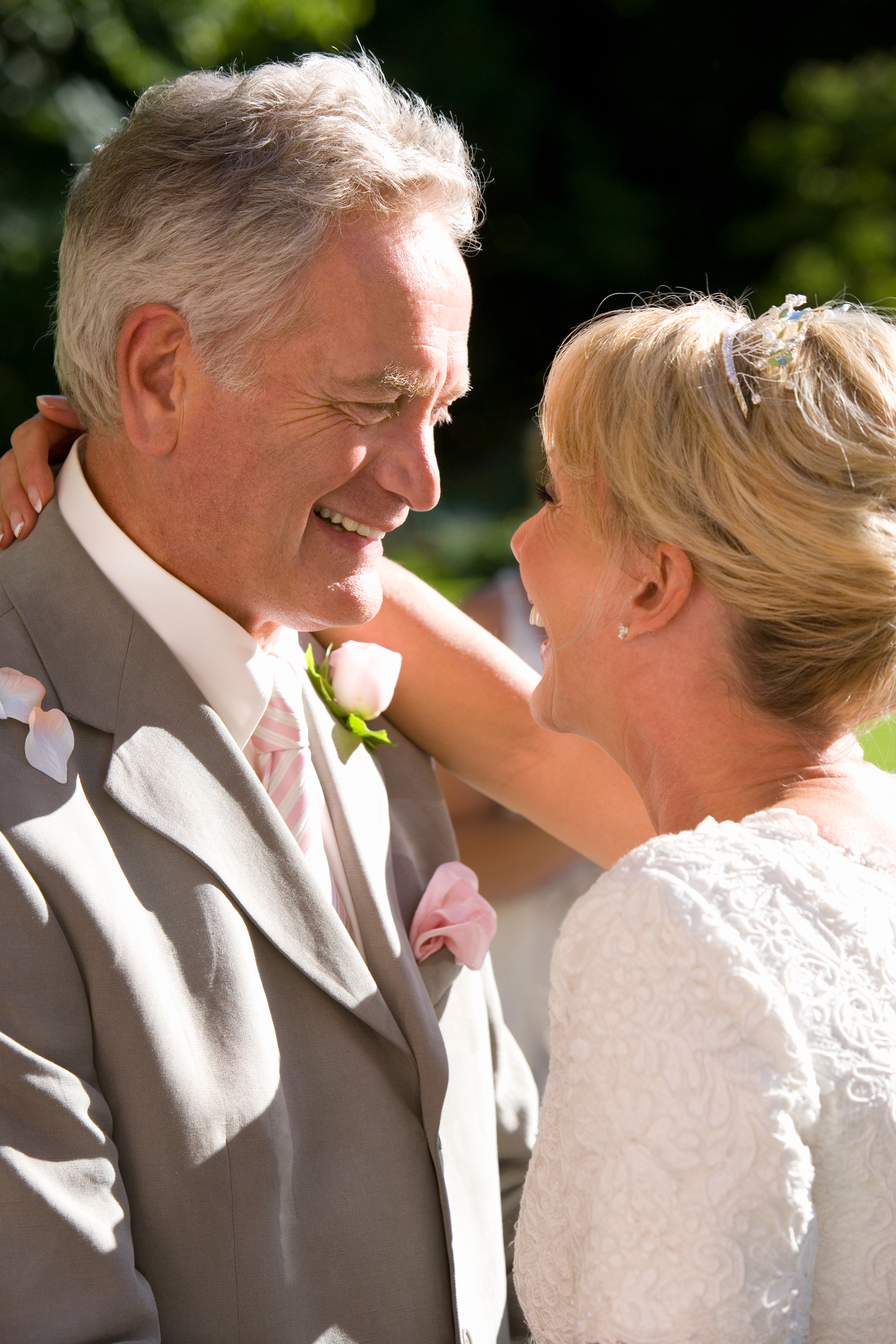 Ein liebevolles älteres Paar, das sich während einer Hochzeit umarmt | Quelle: Shutterstock