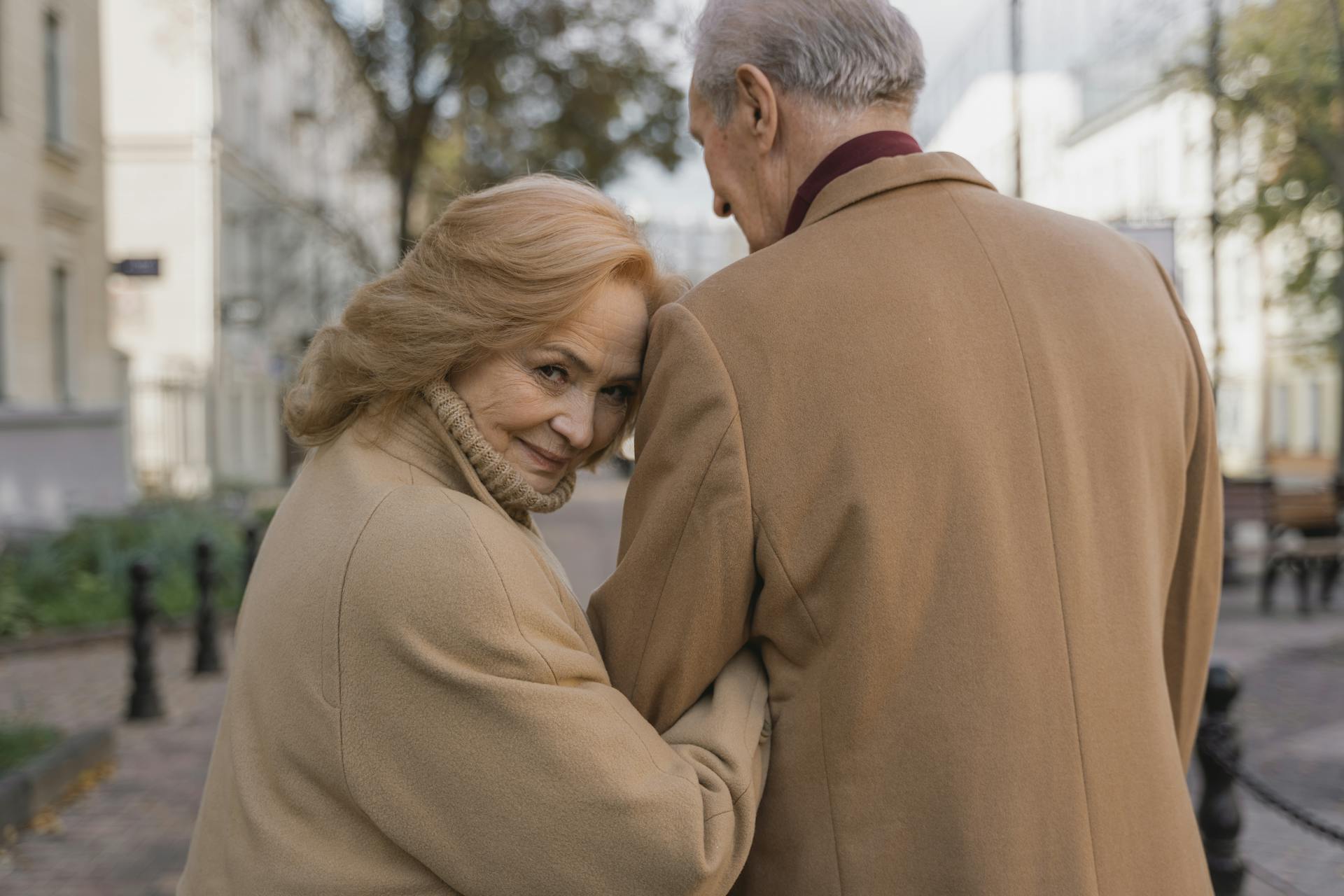 Eine glückliche Frau schaut zurück, während sie mit einem Mann spazieren geht | Quelle: Pexels