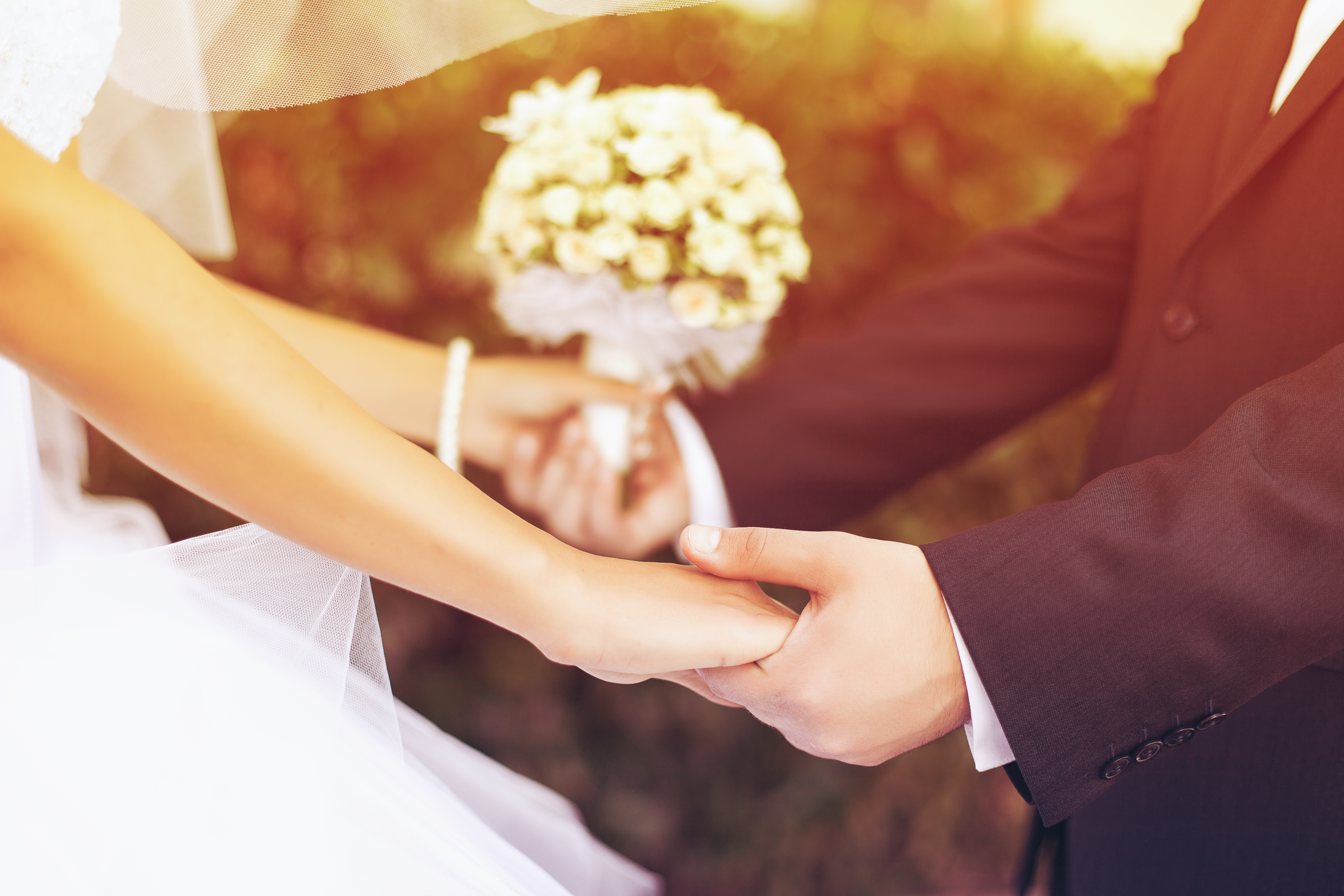 Ein Bräutigam hält die Hand seiner Braut | Quelle: Shutterstock