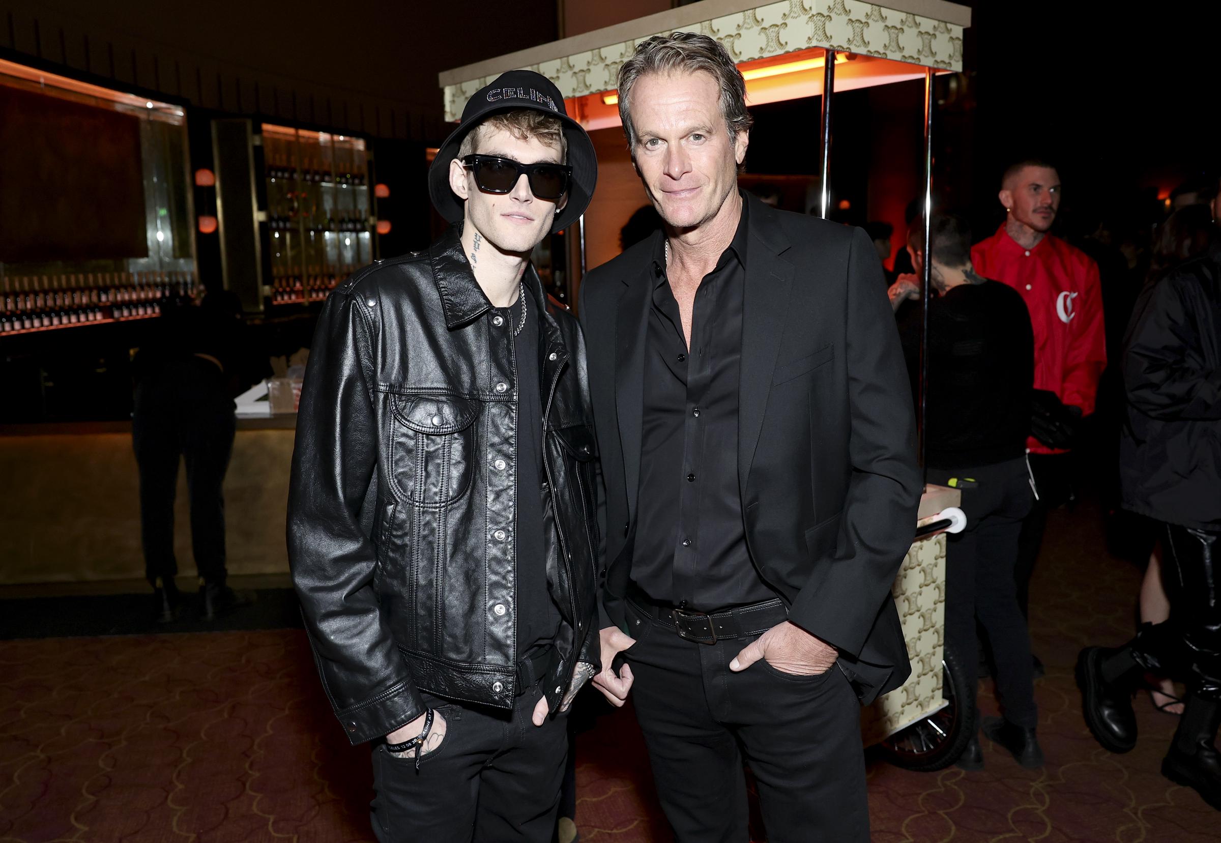 Presley Walker Gerber stand am 8. Dezember 2022 in Los Angeles, Kalifornien, bei der Celine-Modenschau im „The Wiltern“ an der Seite seines Vaters Rande Gerber. Das Vater-Sohn-Duo war in schicken, komplett schwarzen Outfits aufeinander abgestimmt: Presley trug eine coole, übergroße Leder-Bikerjacke, dazu eine dunkle Sonnenbrille, einen Celine-Bucket-Hat und silberne Ketten, während Rande sich für einen maßgeschneiderten Anzug und ein Hemd mit Knöpfen entschied. | Quelle: Getty Images