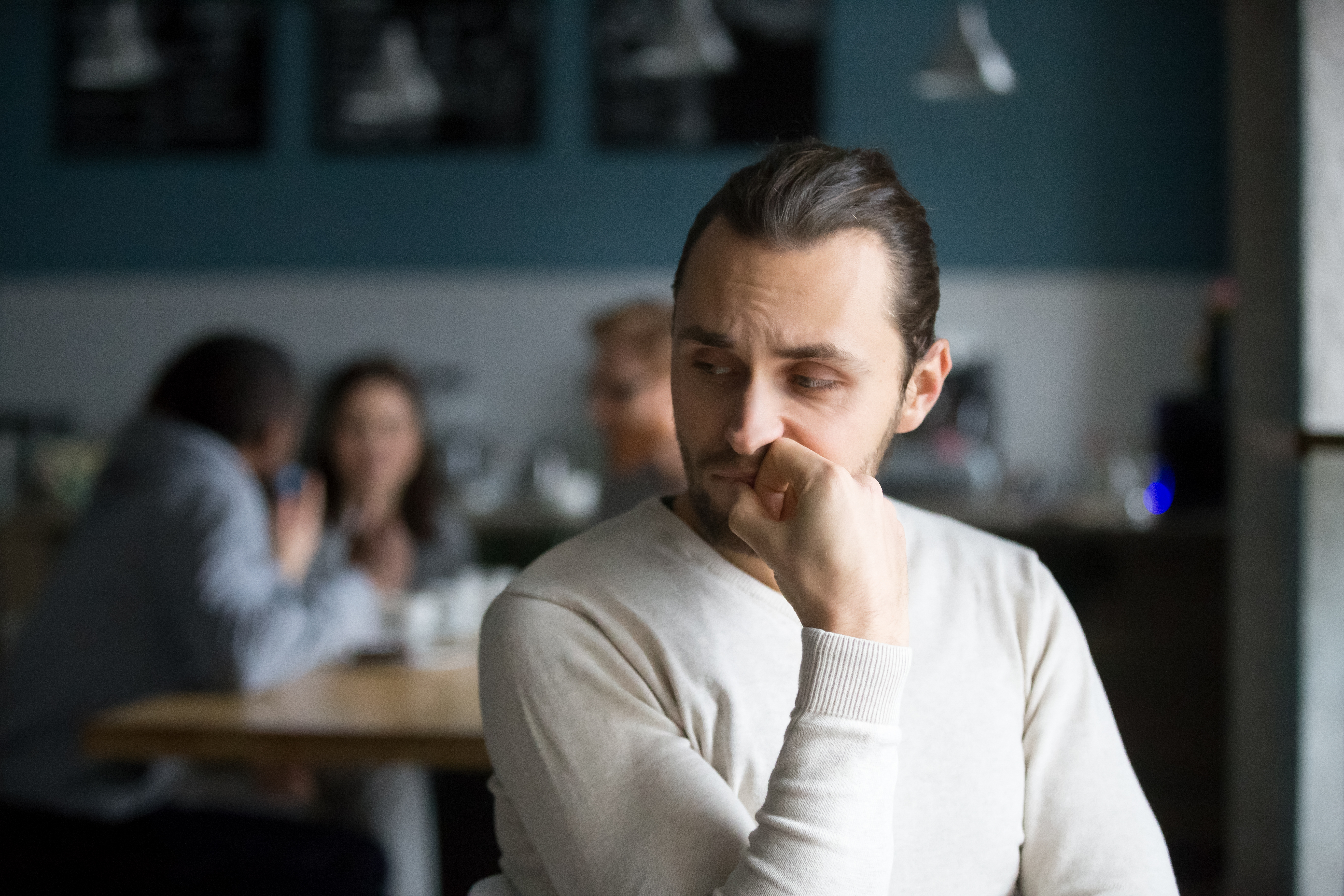 Ein junger Mann sitzt allein in einem Restaurant | Quelle: Shutterstock