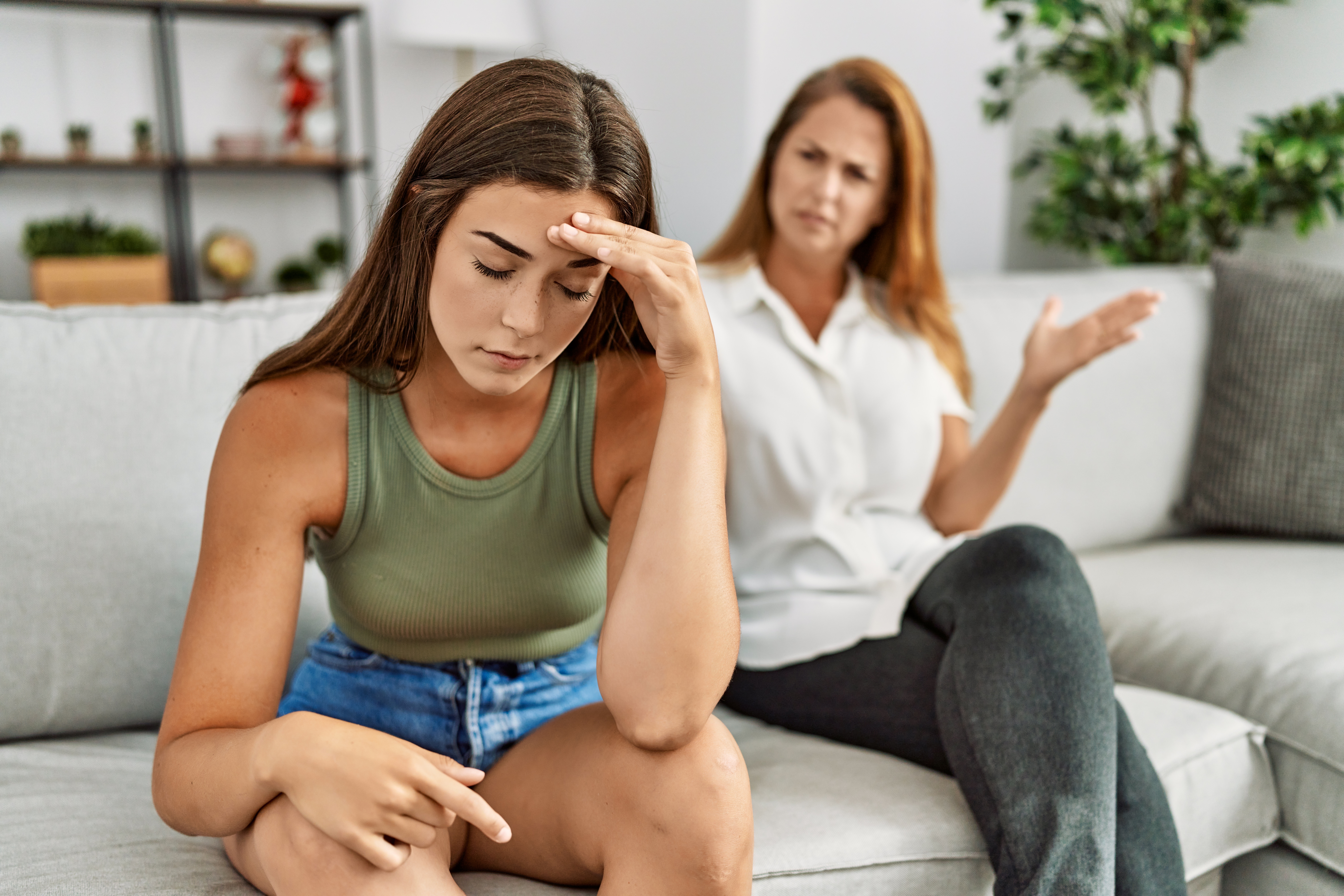Eine junge Frau fühlt sich während eines Streits mit ihrer Mutter müde | Quelle: Shutterstock