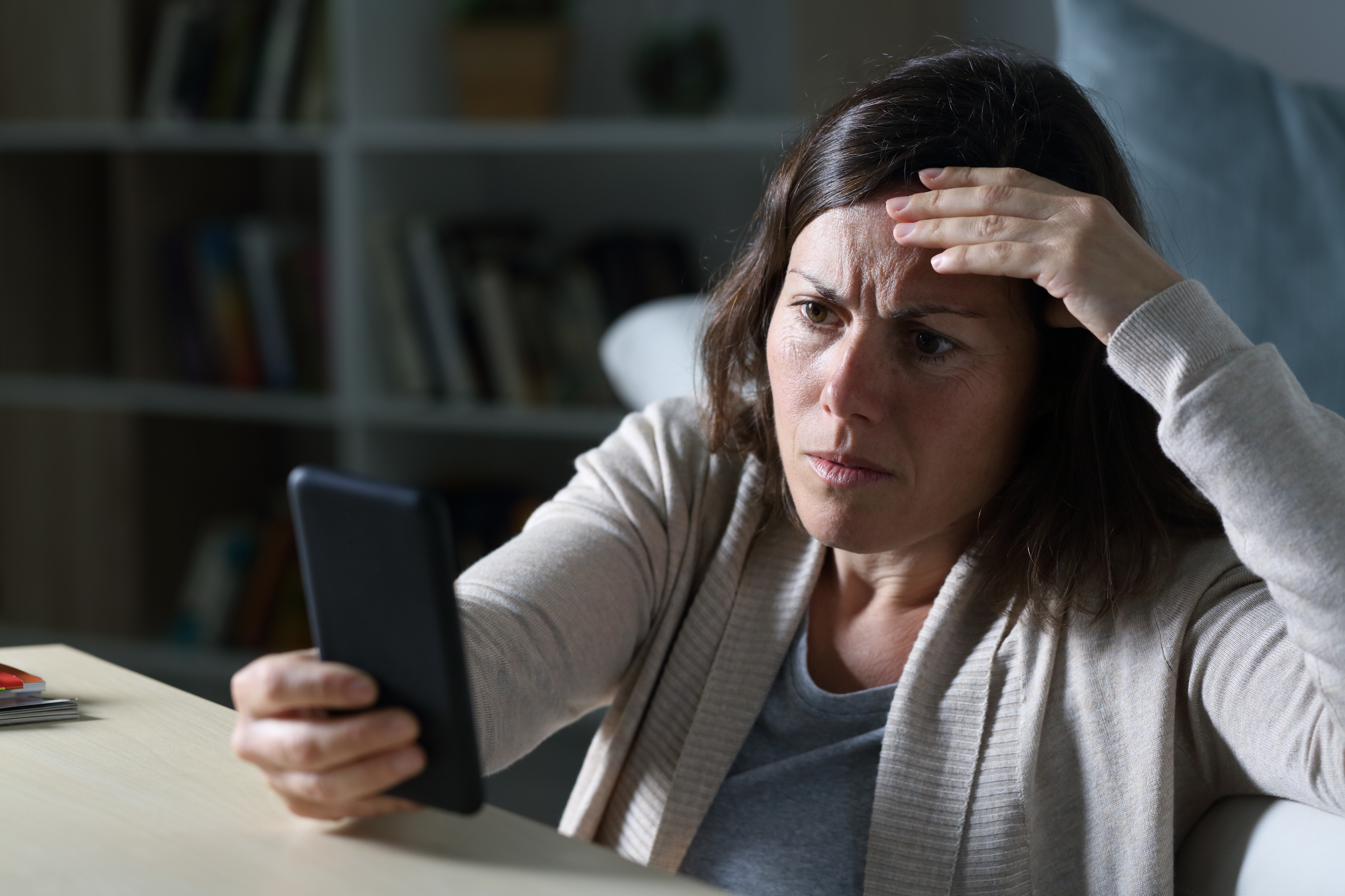 Eine Frau, die besorgt auf ein Telefon starrt | Quelle: Shutterstock