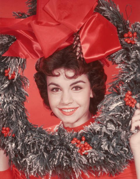 Annette Funicello posiert mit einem dekorativen Weihnachtskranz auf dem Kopf, ca. 1955. | Quelle: Getty Images