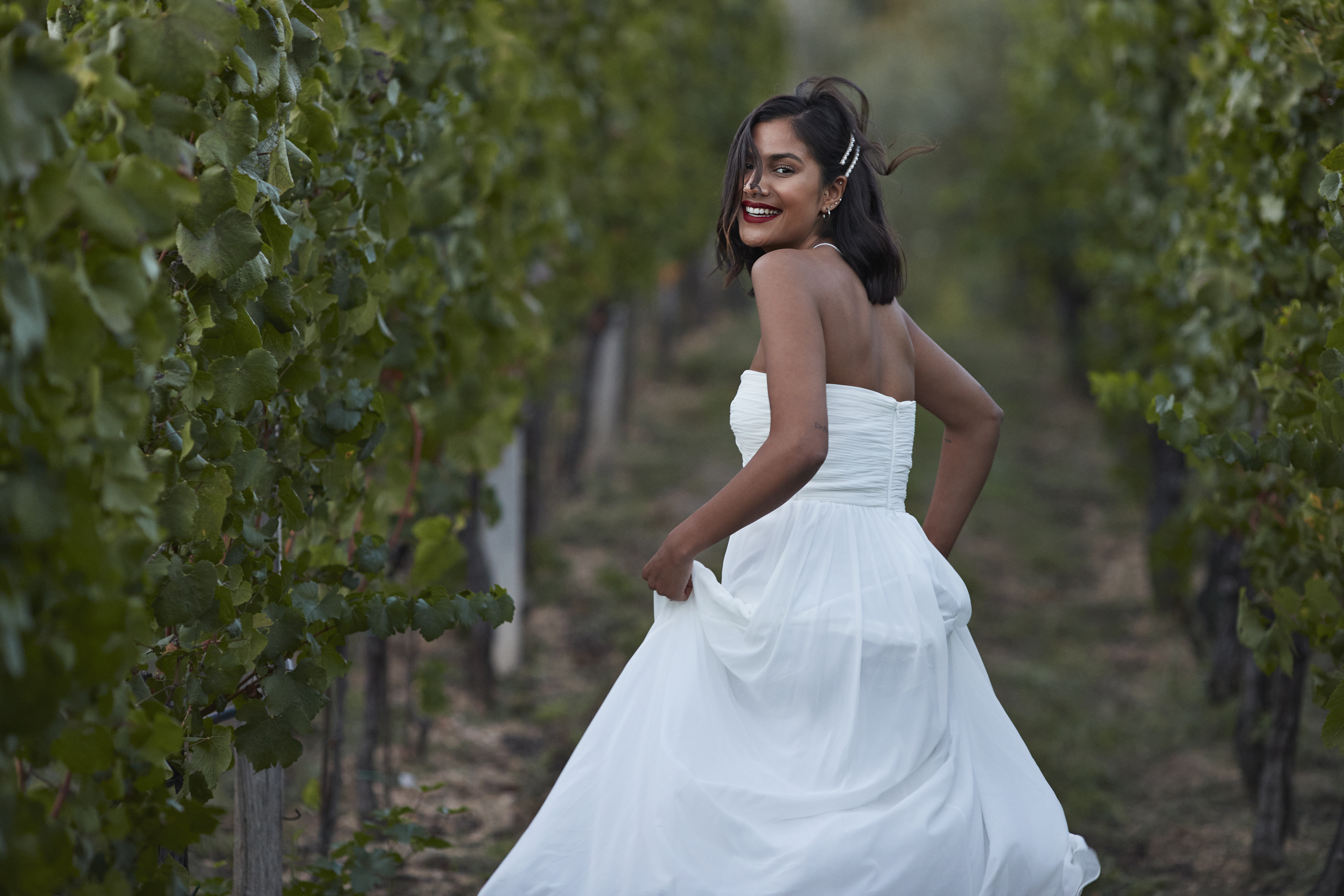 Eine Frau in einem Feld, lächelnd in ihrem Hochzeitskleid | Quelle: Getty Images